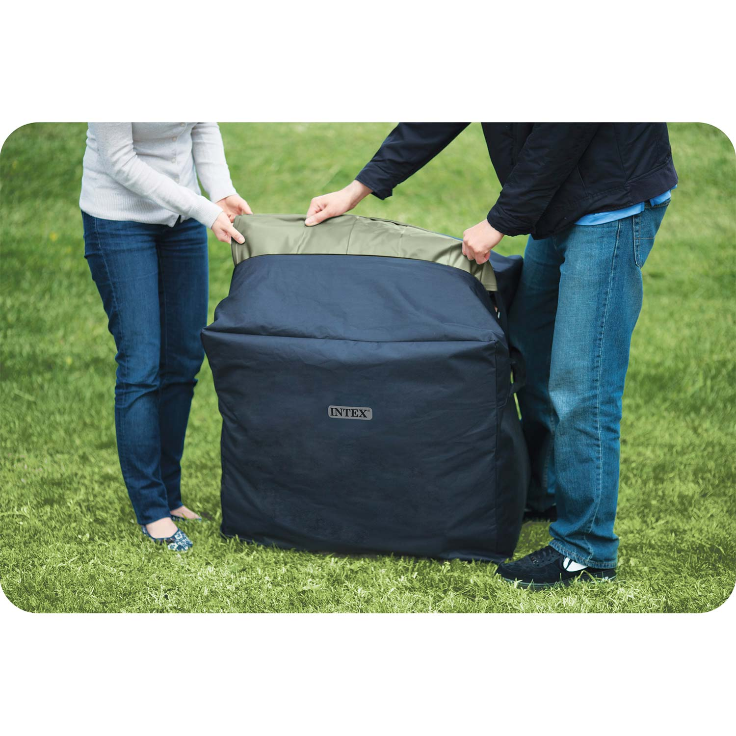 Zwei Personen packen einen schwarzen Intex-Beutel im Freien auf einer grünen Wiese ein.