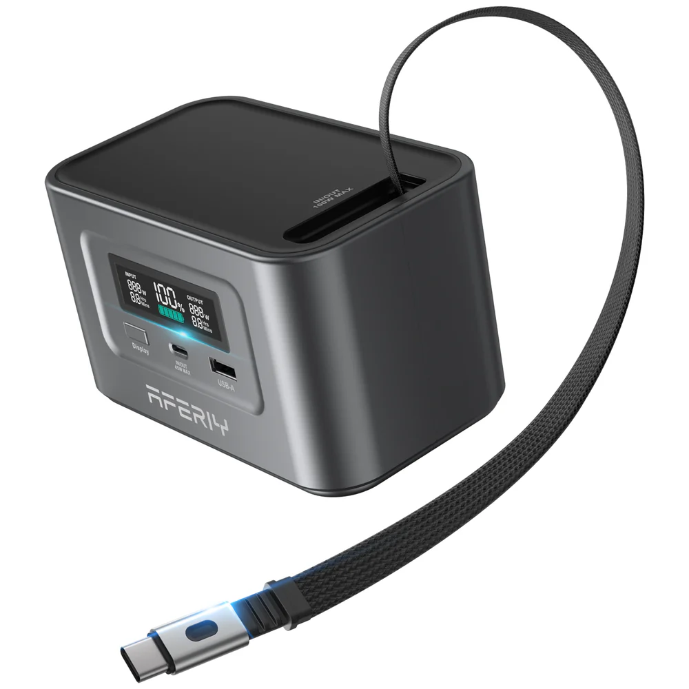 Batería externa gris con pantalla digital mostrando 100% de carga. Cable USB-C conectado.