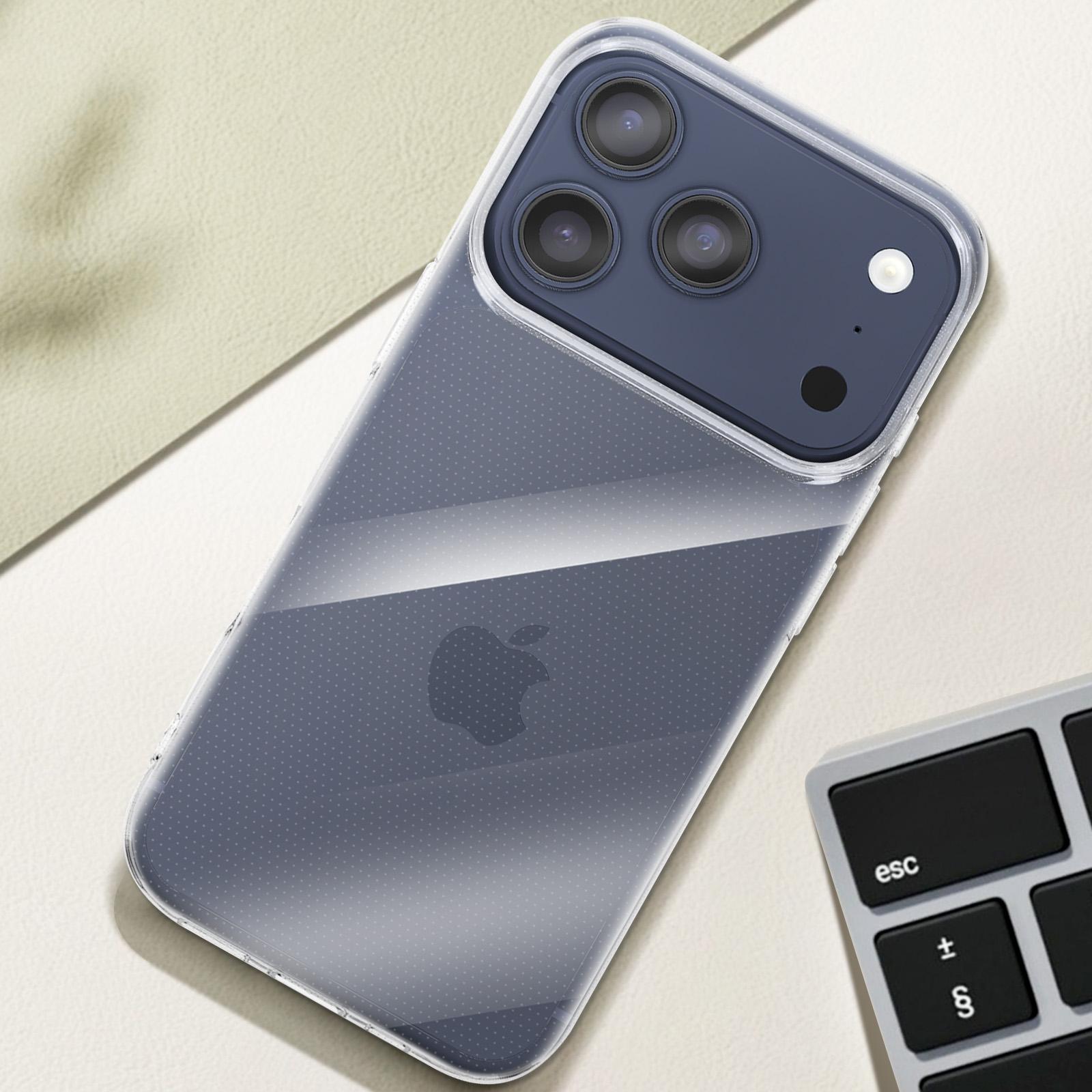 Klare Handyhülle mit Apple-Logo auf einem Schreibtisch neben einer Tastatur.