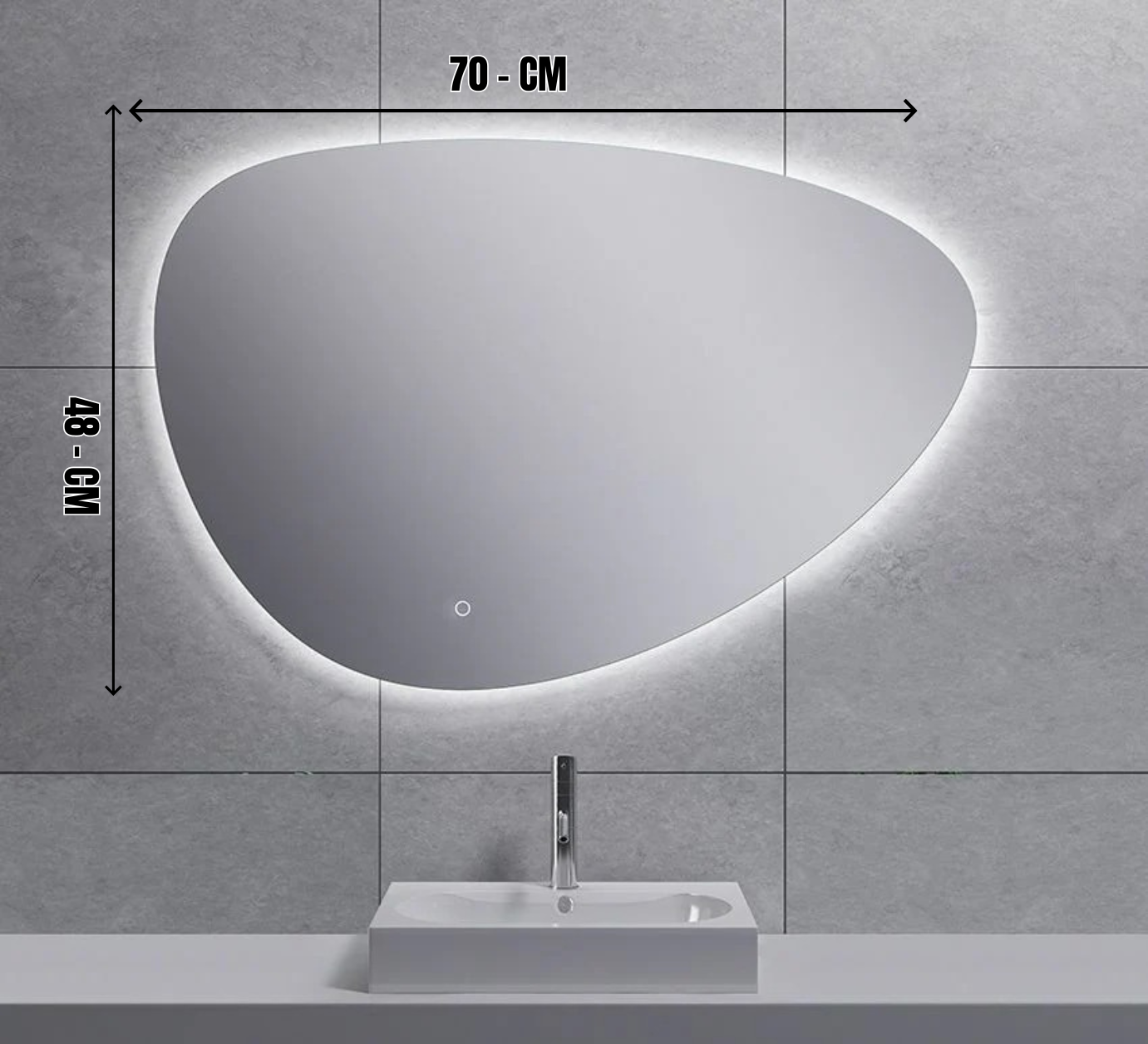 Een verlichte, asymmetrische spiegel boven een witte wastafel tegen een betegelde muur.
