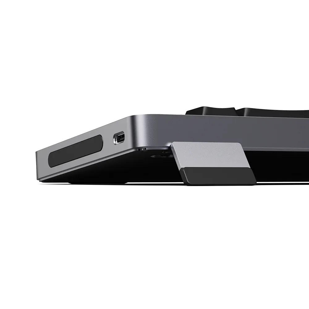 Szara klawiatura z portem USB-C i rozkładaną podstawką.