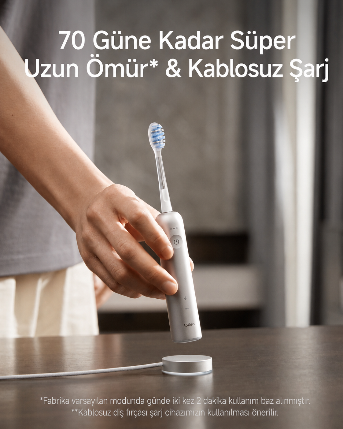 Bir el, şarj istasyonunun üzerinde gümüş renkli elektrikli diş fırçası tutuyor.
