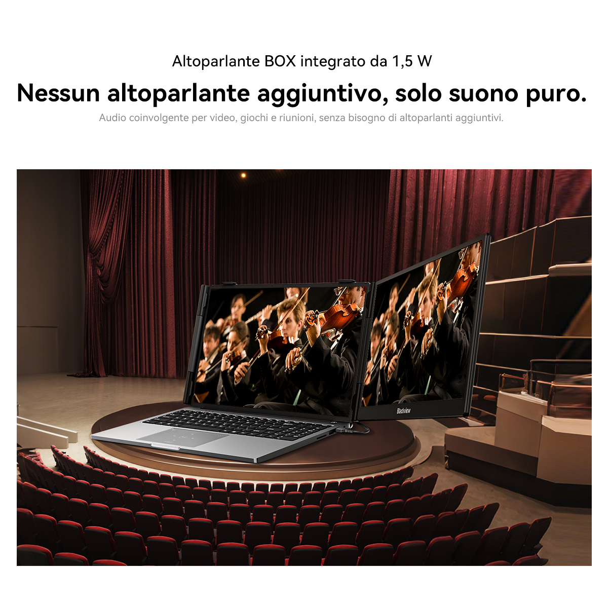 Un laptop con due monitor esterni che mostrano un'orchestra, in un teatro.