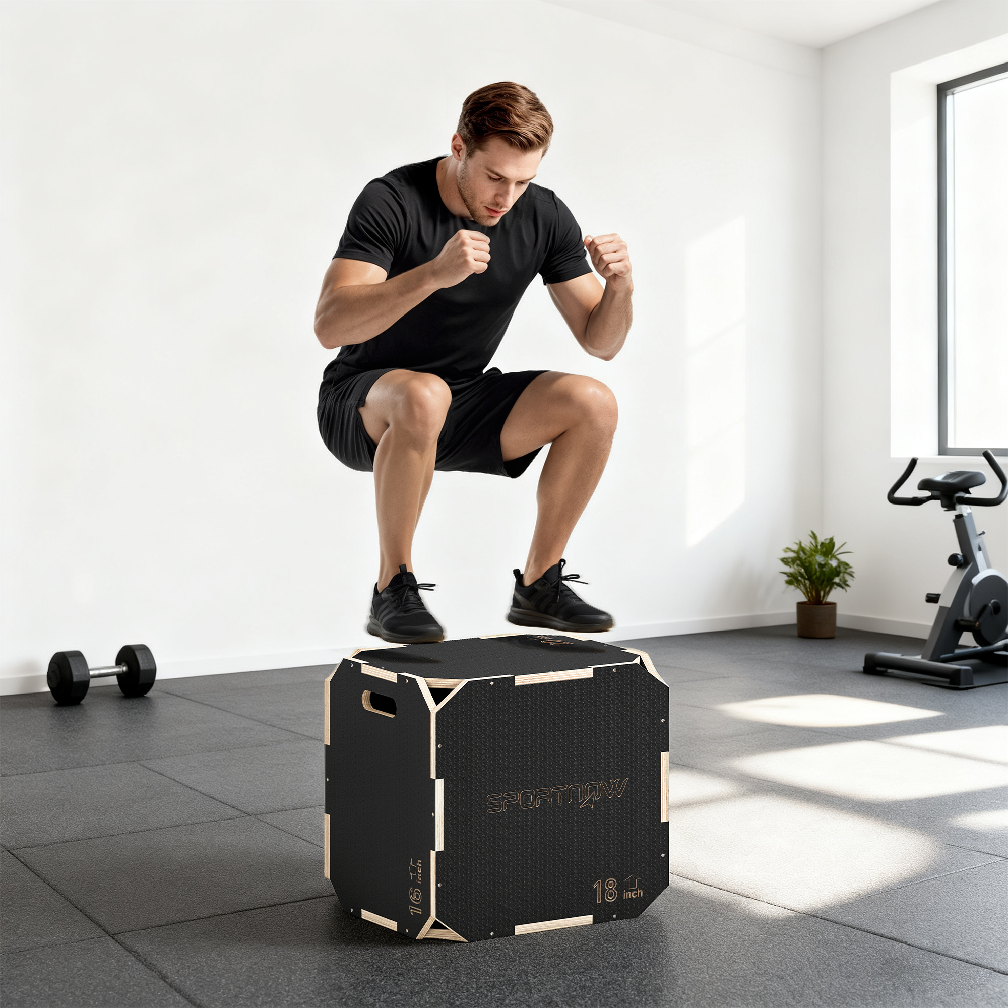 Hombre saltando sobre una caja negra en un gimnasio con pesas y bicicleta.