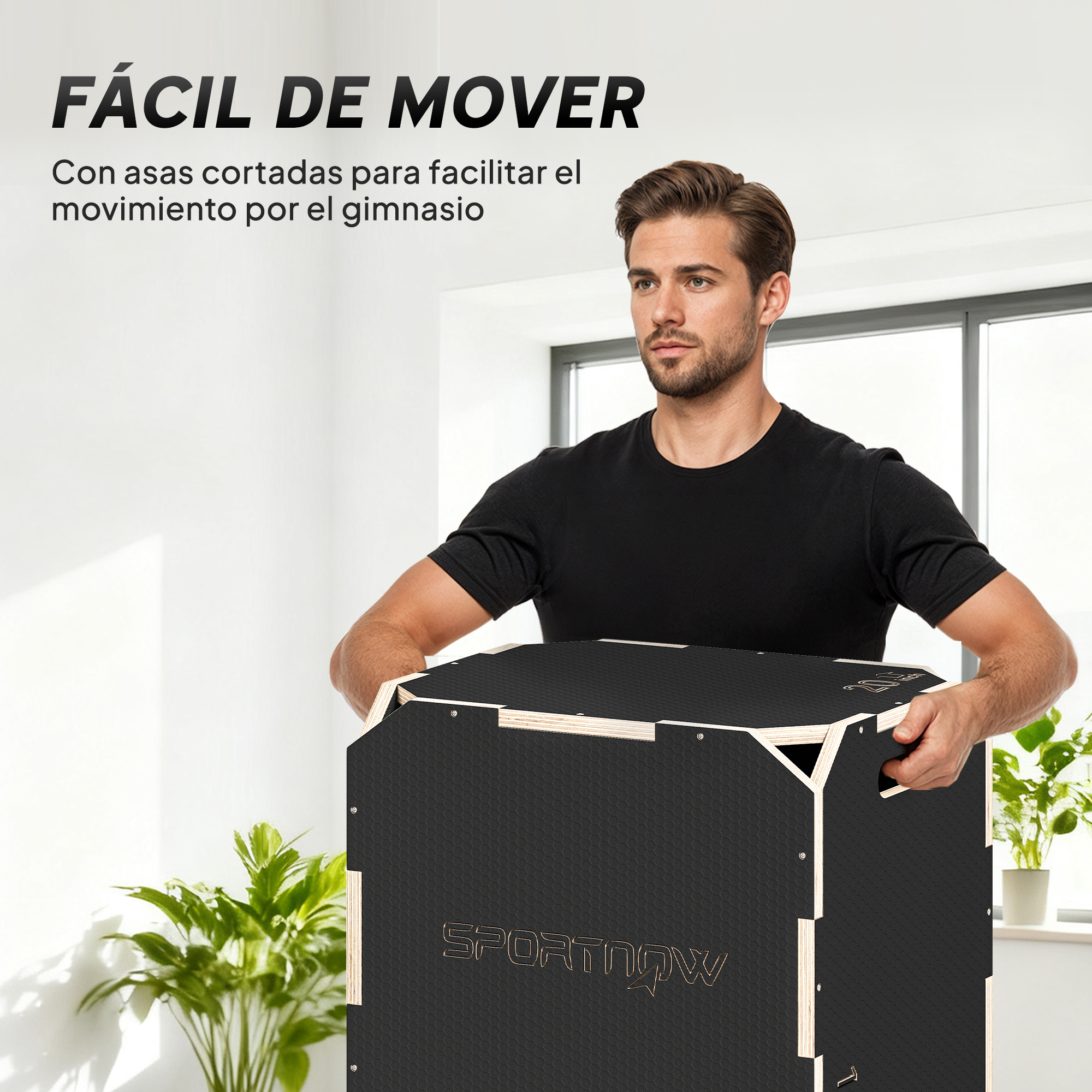 Un hombre con camiseta negra lleva una caja pliométrica negra con detalles de madera.