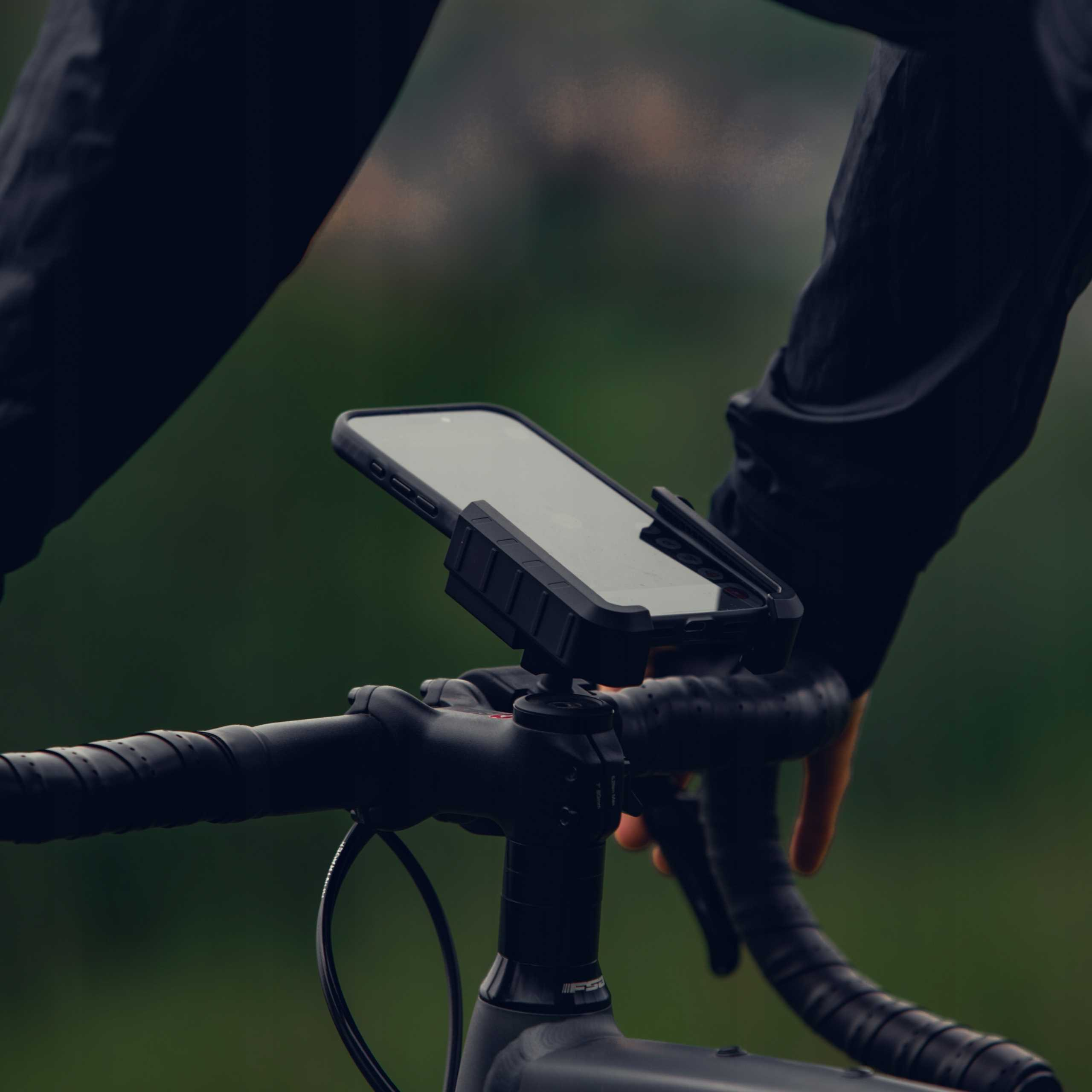Smartfon zamontowany na kierownicy roweru. Detale: Kolor czarny.