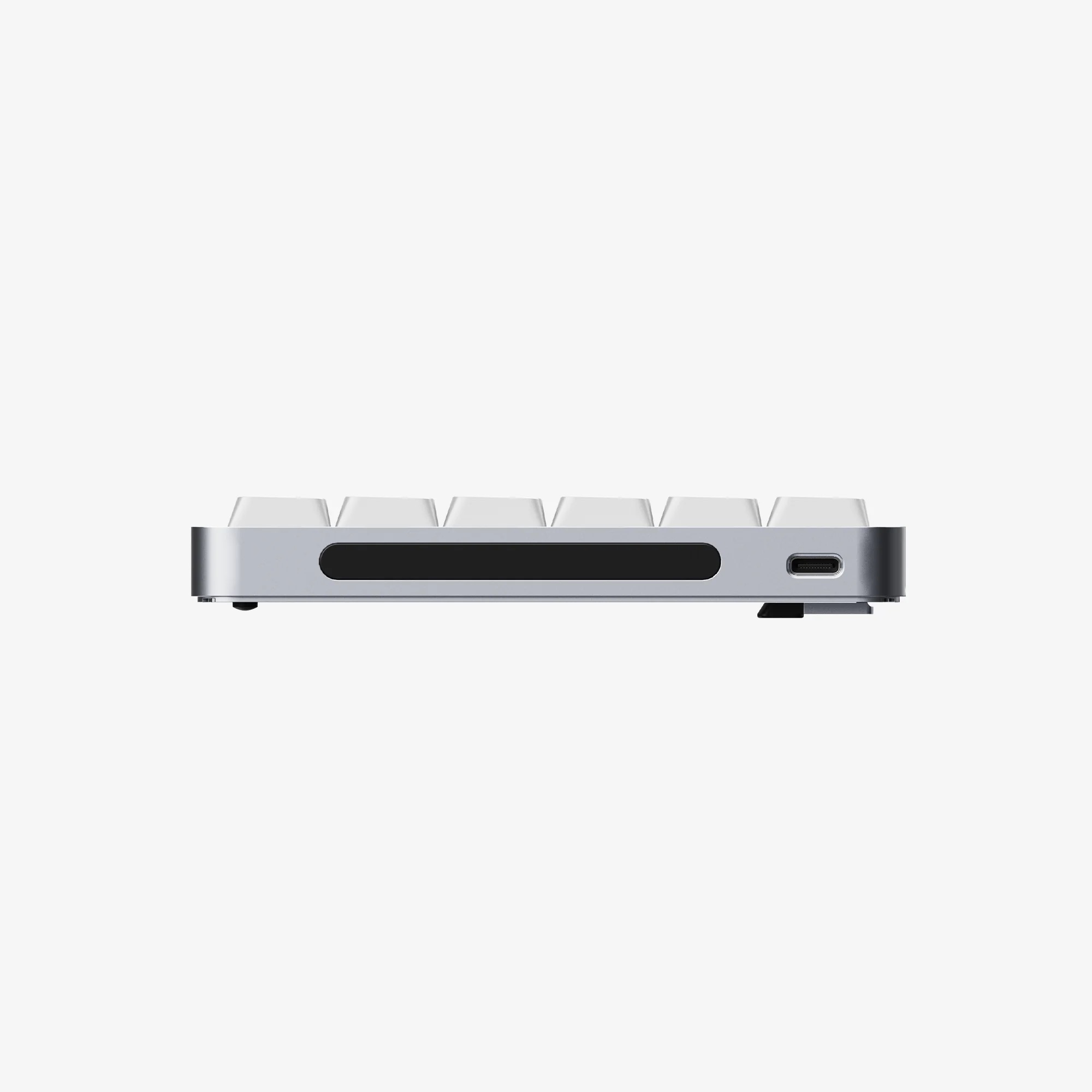 Srebrna klawiatura z białymi klawiszami, port USB-C z boku.