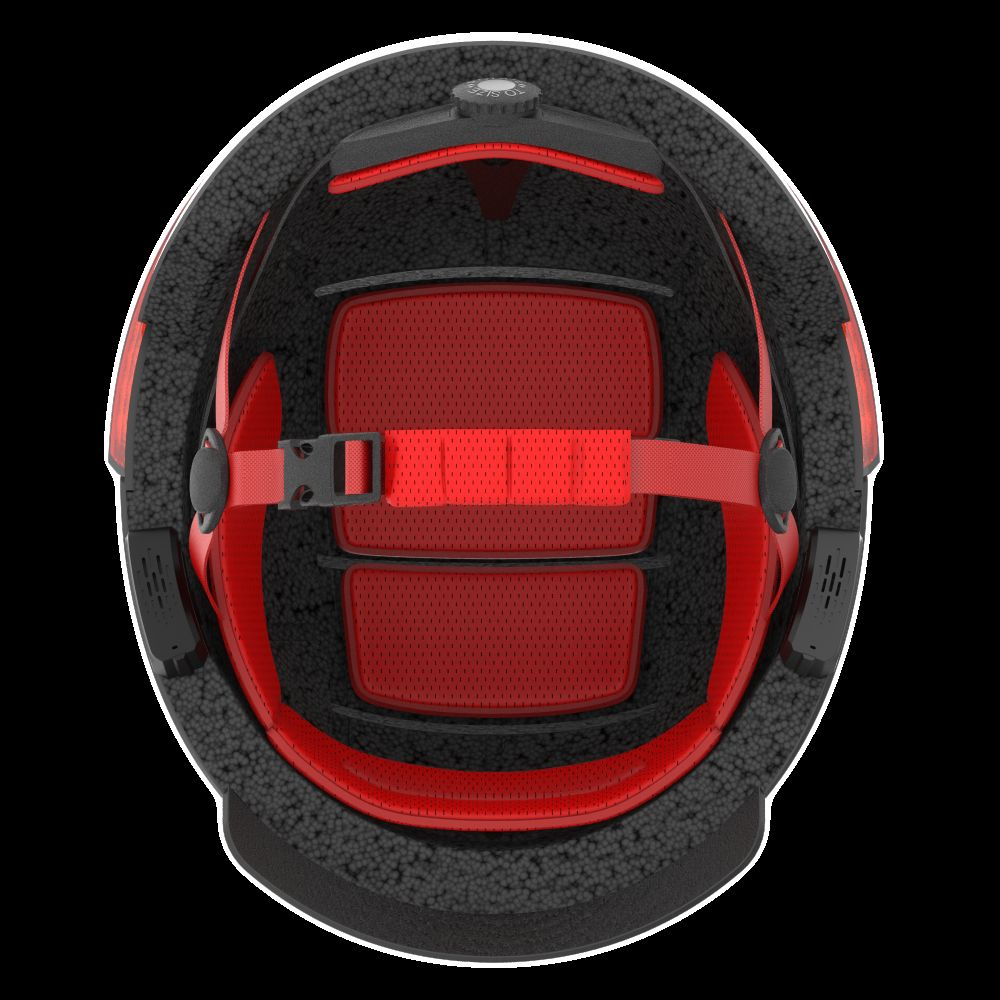 Vista dall'alto di un casco da sci nero con imbottitura rossa e cinghie.