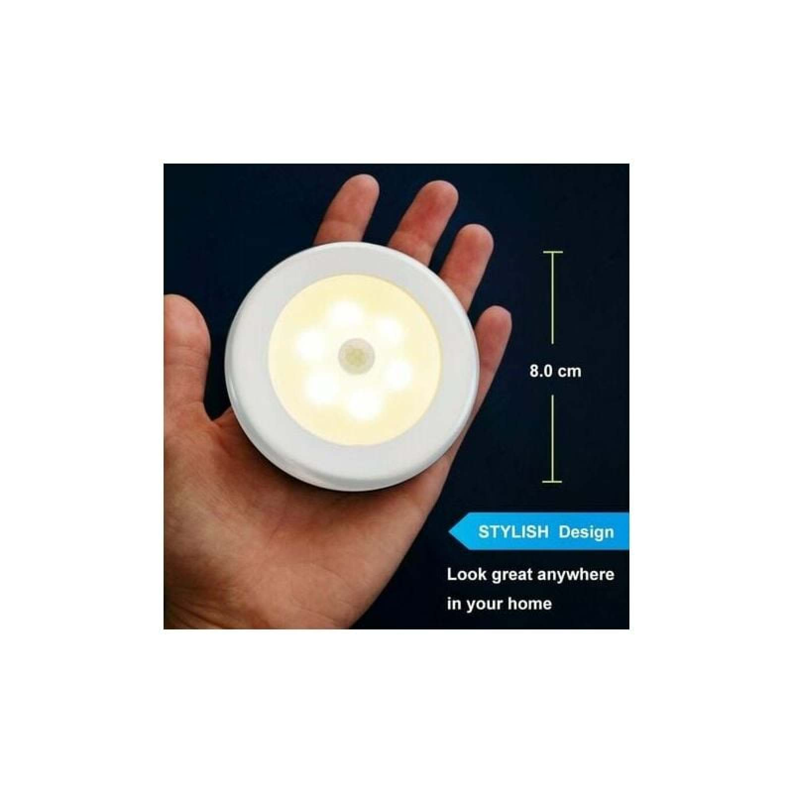 Eine runde, weiße Lampe mit sechs LEDs wird in einer Hand gehalten.