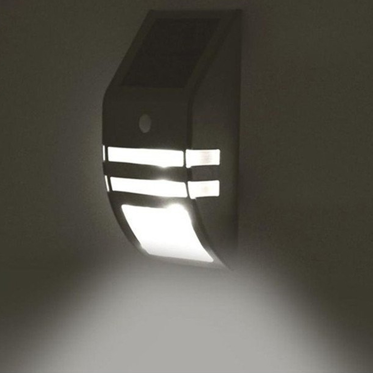 Ein dunkles Wandlicht mit Solarpanel und Bewegungssensor, das nach unten leuchtet.