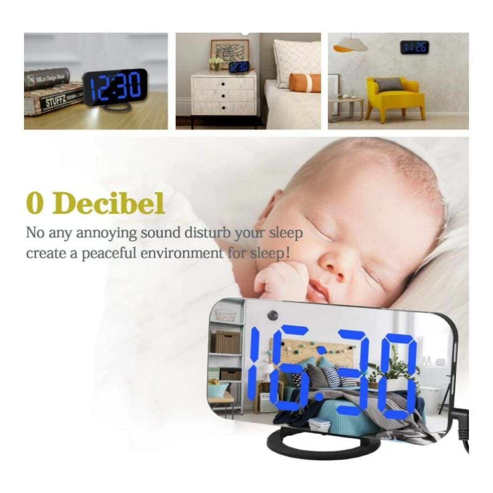 Digitaluhr mit blauen Ziffern auf einem Nachttisch neben einem Baby.