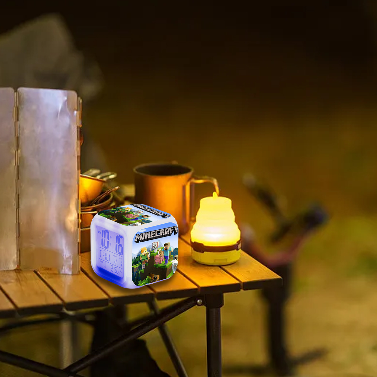 Minecraft-Würfeluhr und Lampe auf einem Holztisch im Freien.