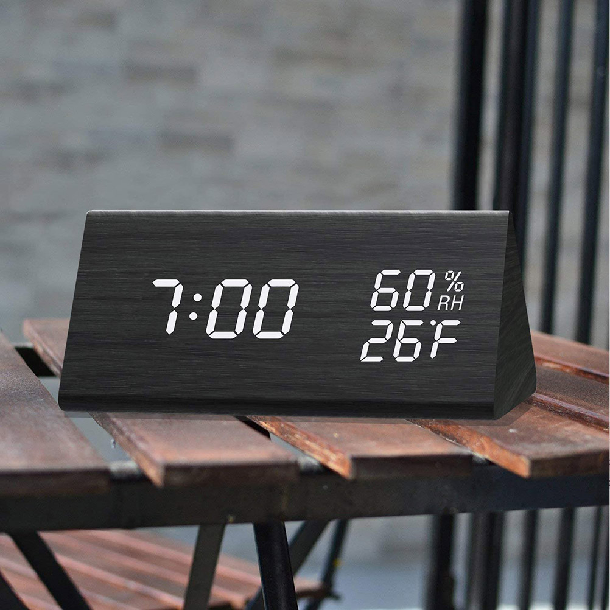 Ein schwarzer digitaler Wecker zeigt 7:00, 60% Luftfeuchtigkeit und 26°F an.