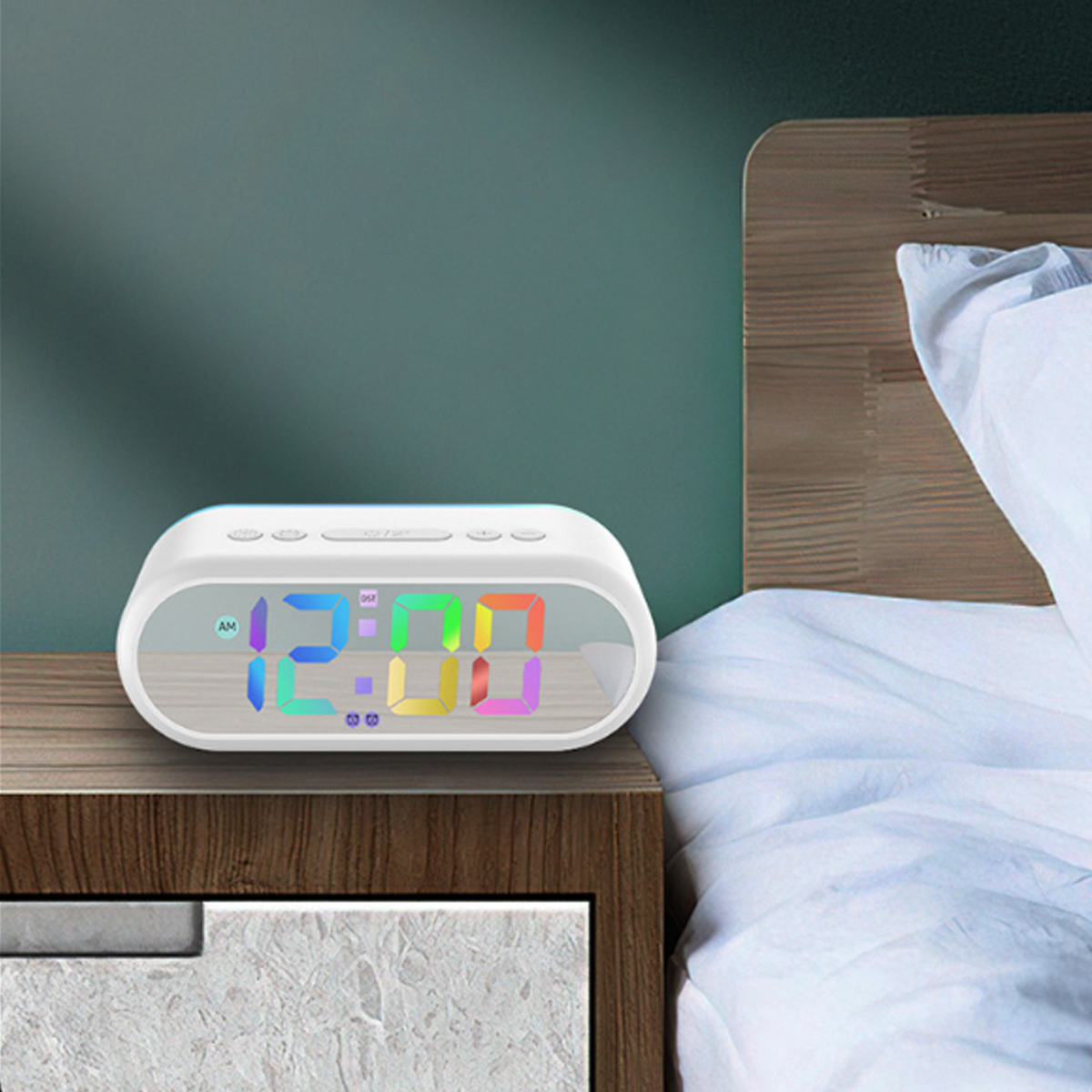Ein weißer Digitalwecker mit bunten Zahlen zeigt 12:00 auf einem Nachttisch.
