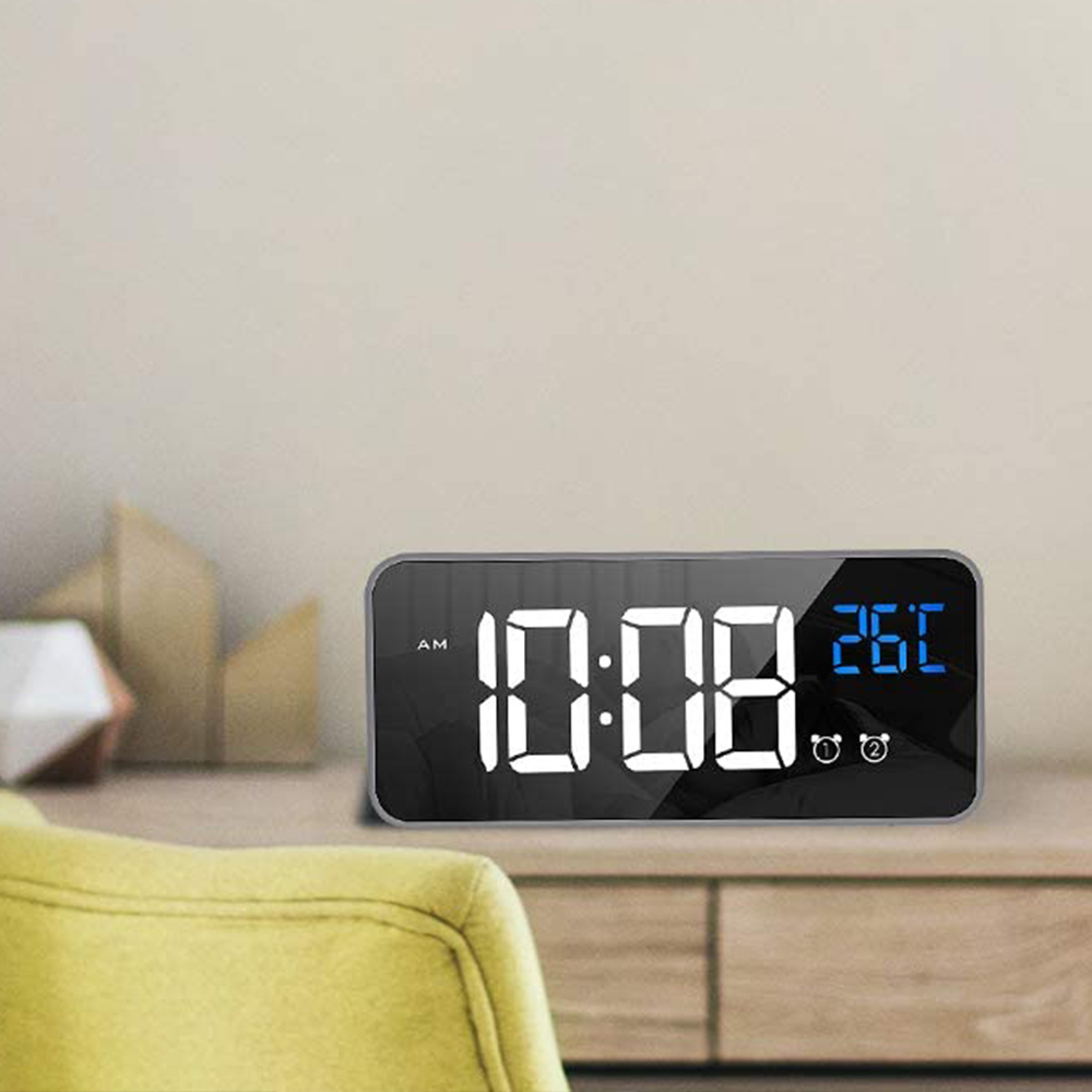 Digitaluhr zeigt 10:08 AM und 26 Grad an. Auf einem Nachttisch.