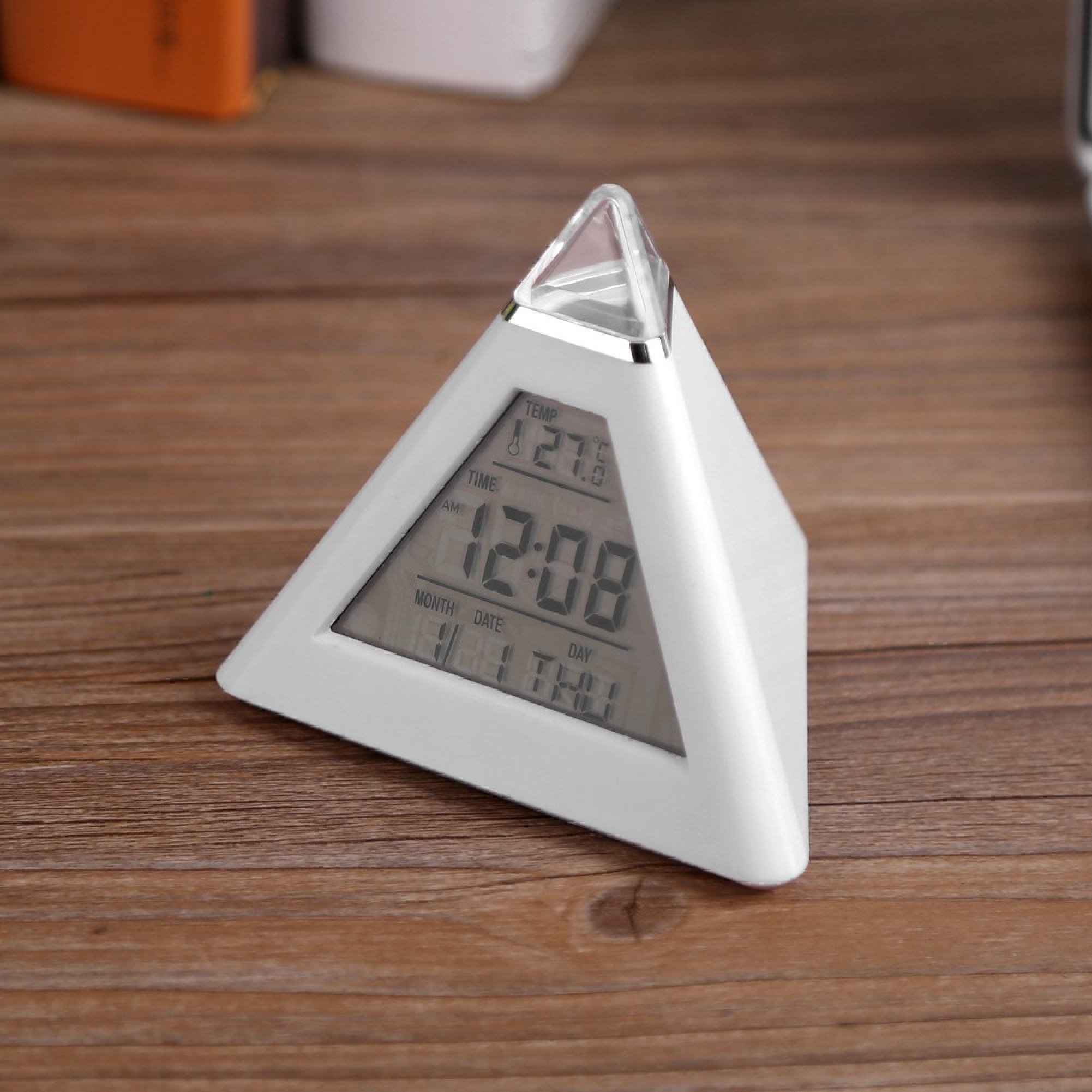 Ein weißer Pyramidenwecker zeigt 12:08 Uhr, 27 Grad und 1. Nov an.