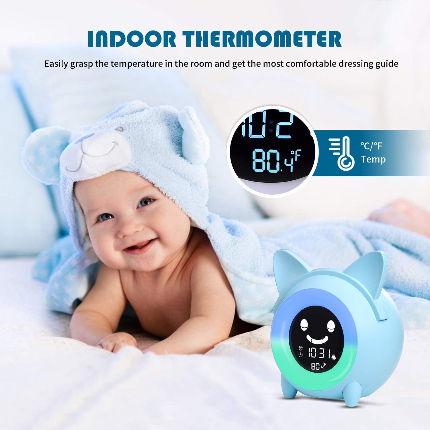 Ein Baby mit blauer Bärenmütze liegt auf einem Bett neben einem blauen Digitalthermometer.