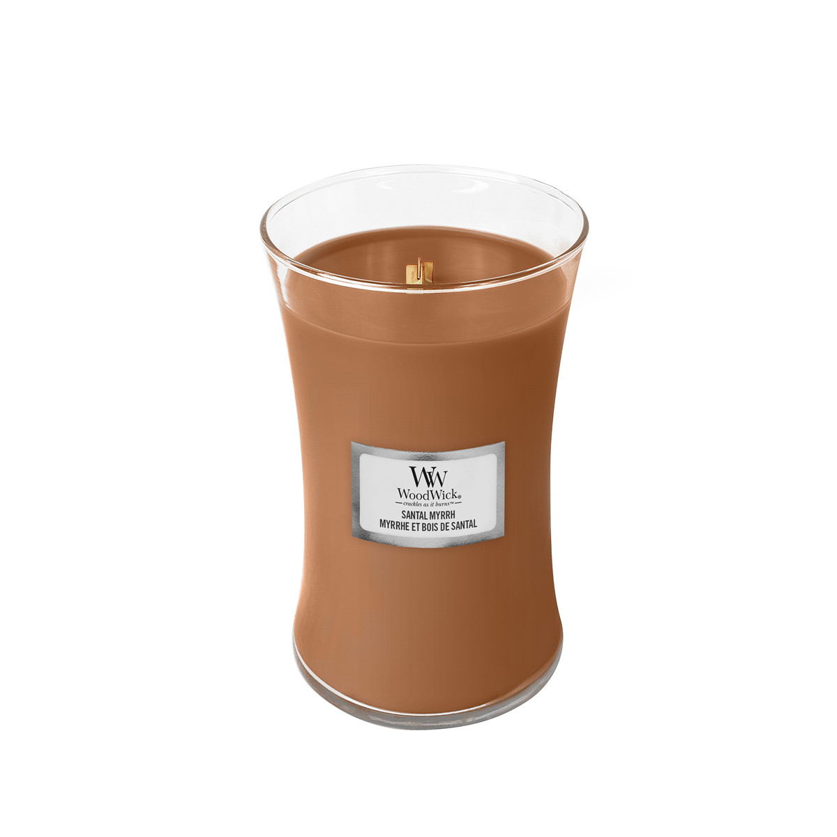 Eine braune Kerze in einem Glasgefäß mit einem Holzdocht und einem silbernen Etikett.