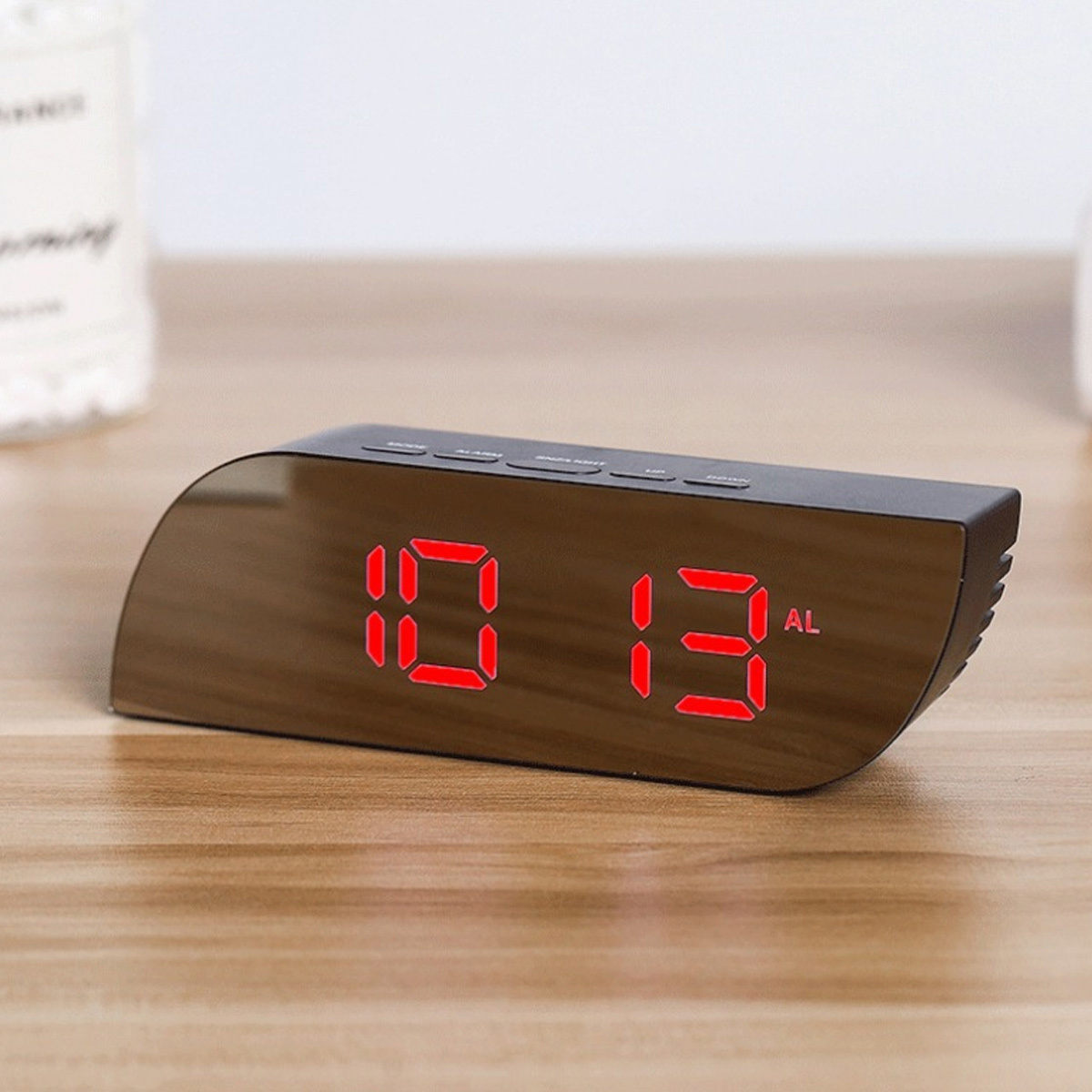 Ein schwarzer Digitalwecker mit rotem LED-Display zeigt 10:13 an.