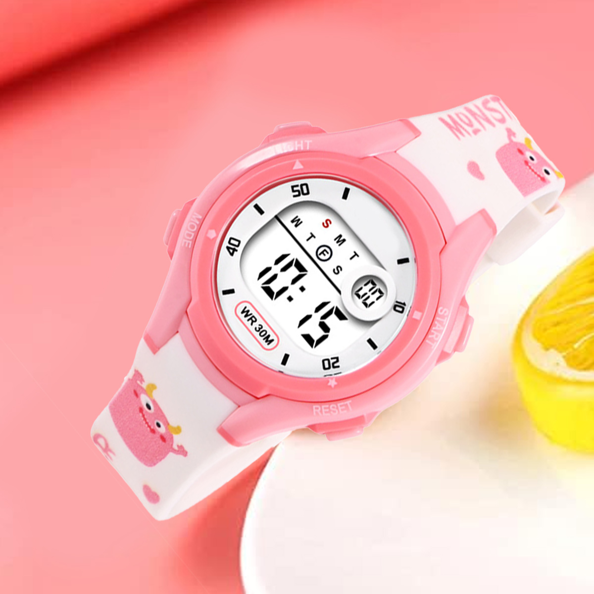 Eine rosafarbene Digitaluhr mit Monstermotiv und weißem Armband.