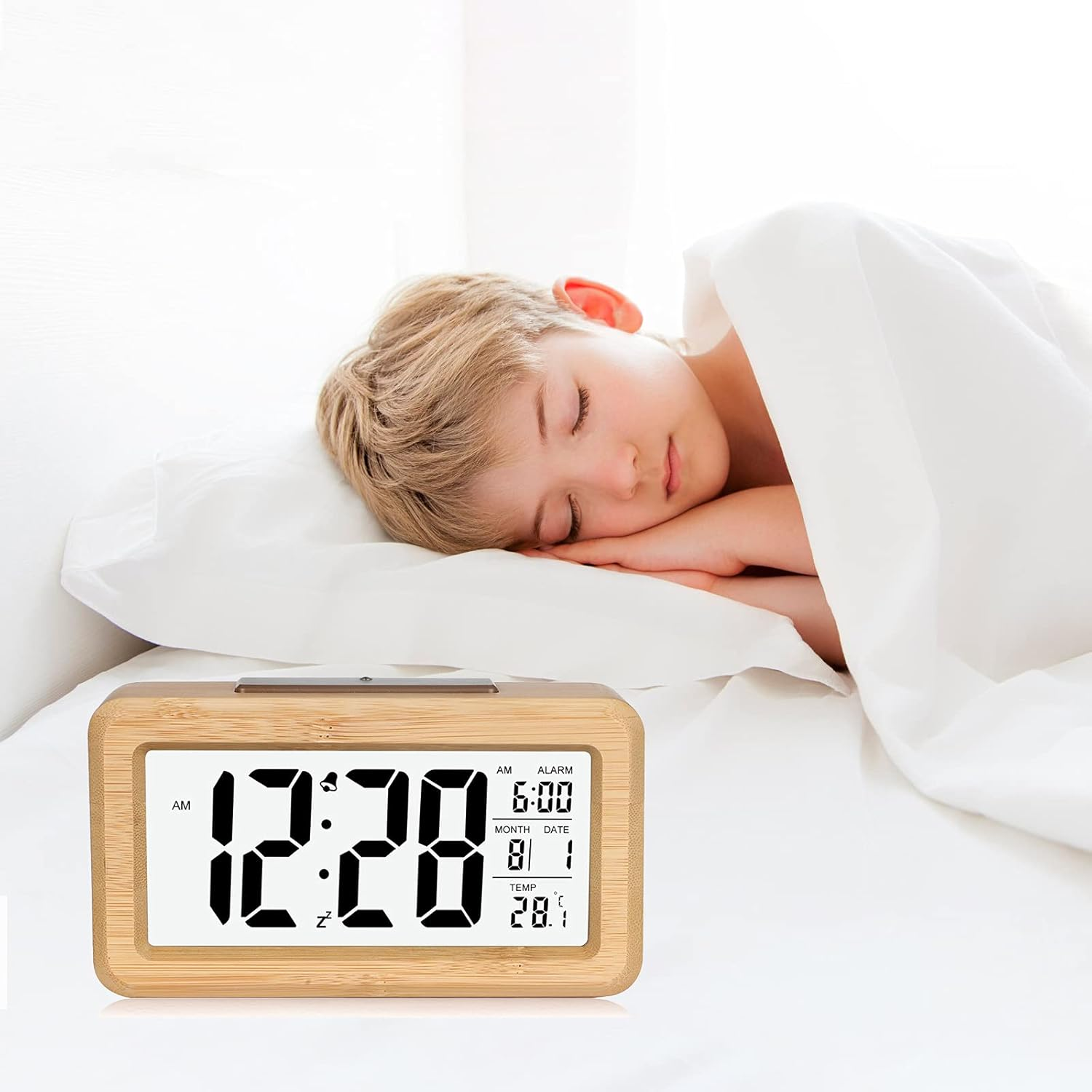 Ein Junge schläft friedlich im Bett neben einem digitalen Wecker.