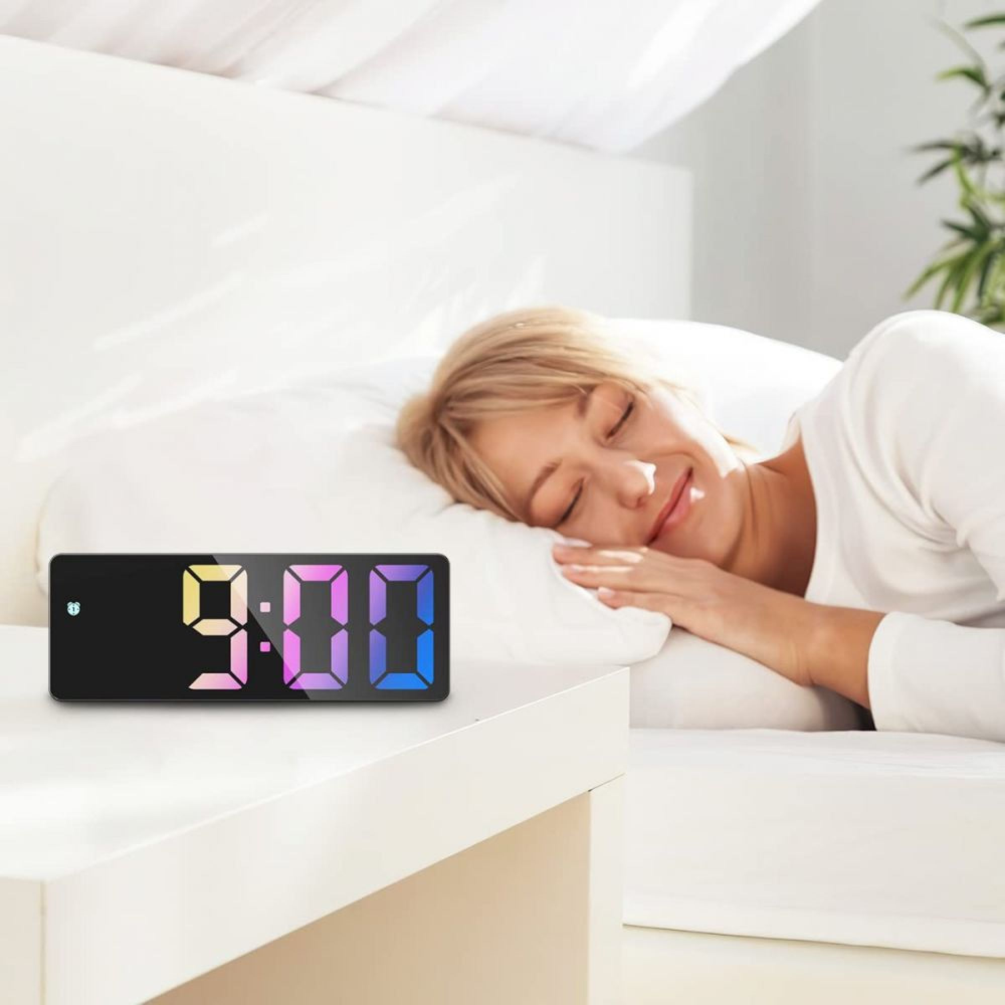 Eine Frau schläft im Bett, ein digitaler Wecker zeigt 9:00 an.
