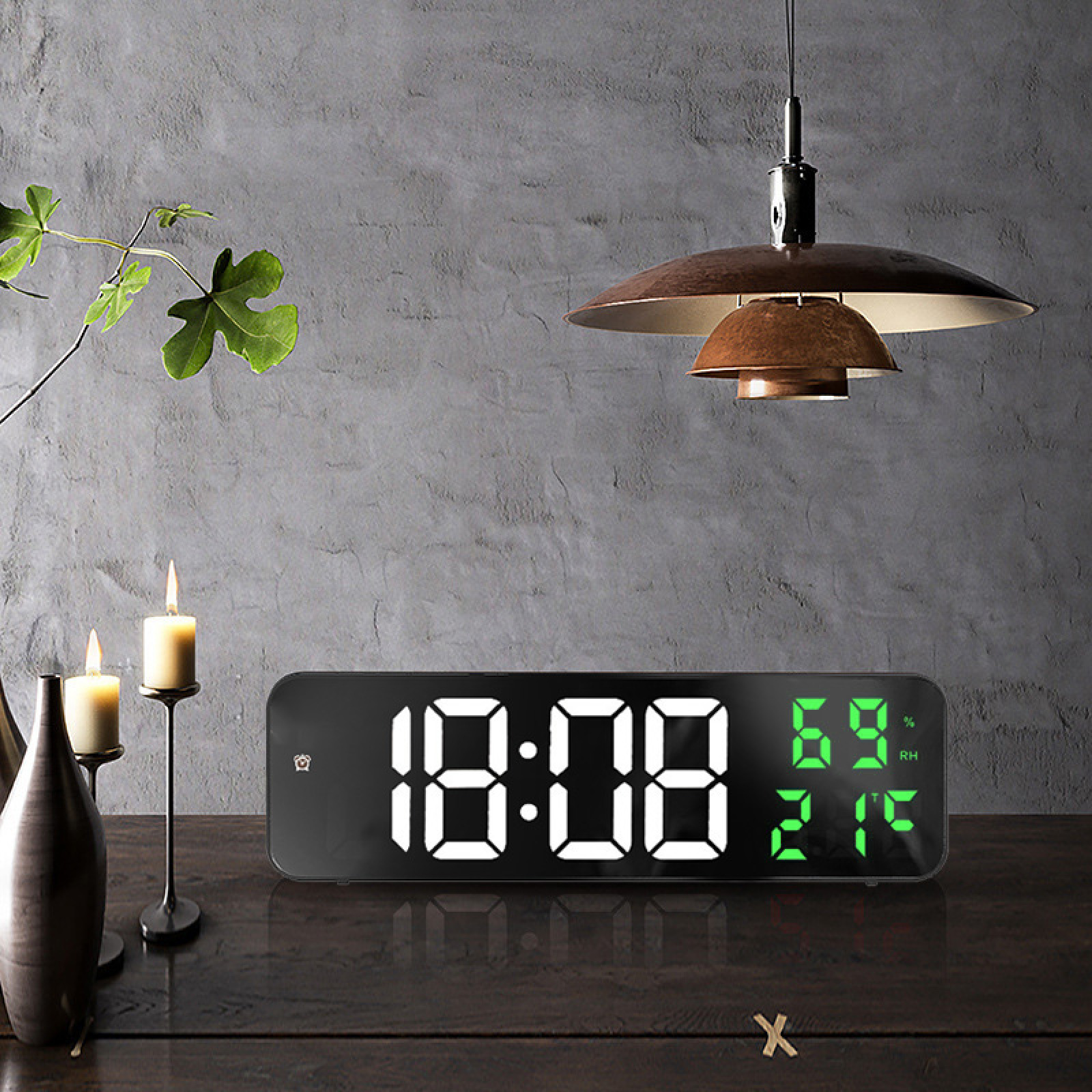 Digitaluhr zeigt 10:08, 69% RH und 21C. Neben zwei brennenden Kerzen und einer Vase.