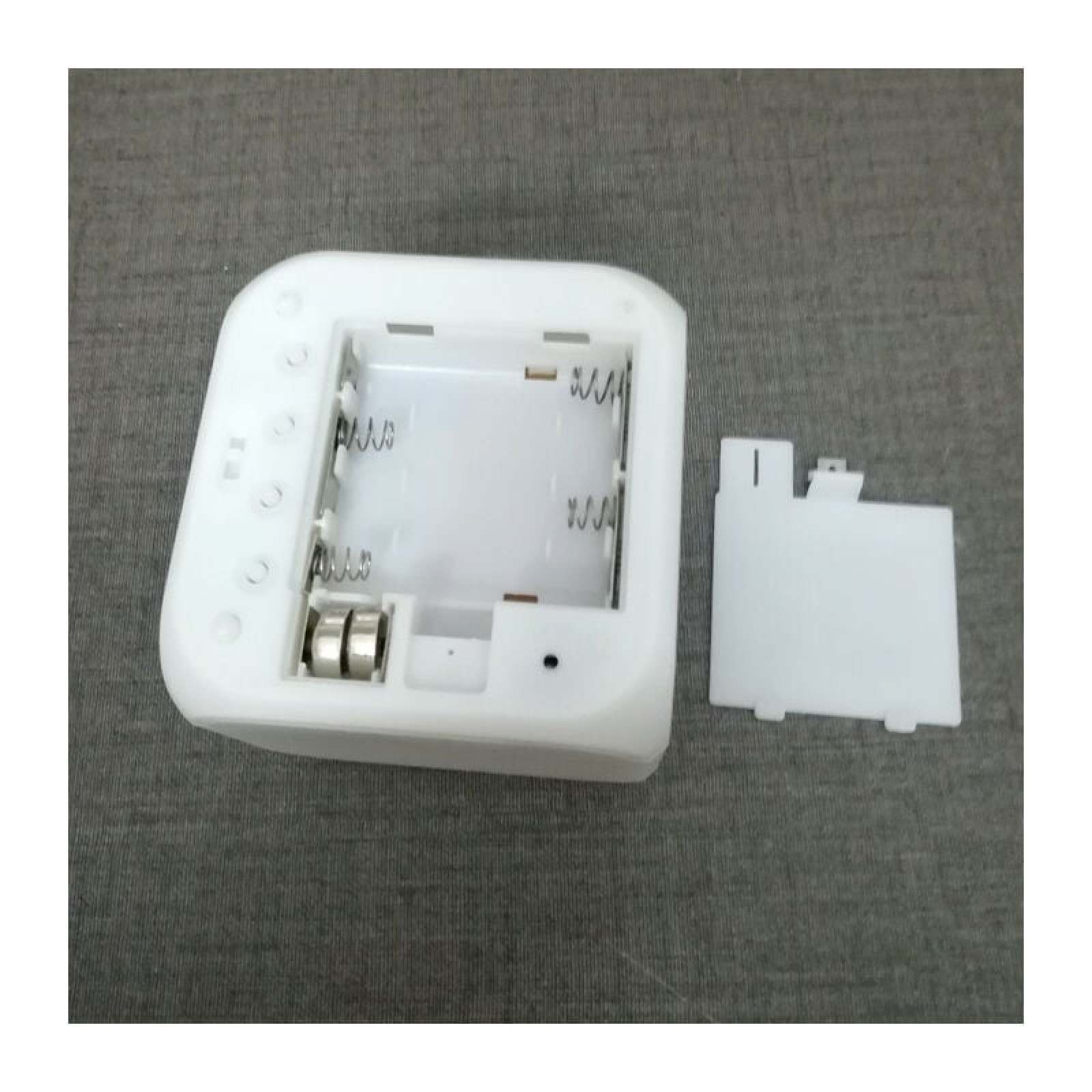 Ein weißes Gehäuse mit freiliegenden Batteriefächern und einer abgenommenen Abdeckung.