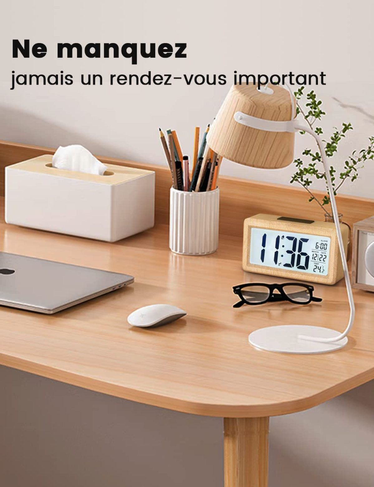 Ein Schreibtisch mit Laptop, Maus, Brille, Lampe, Uhr und Taschentuchbox.
