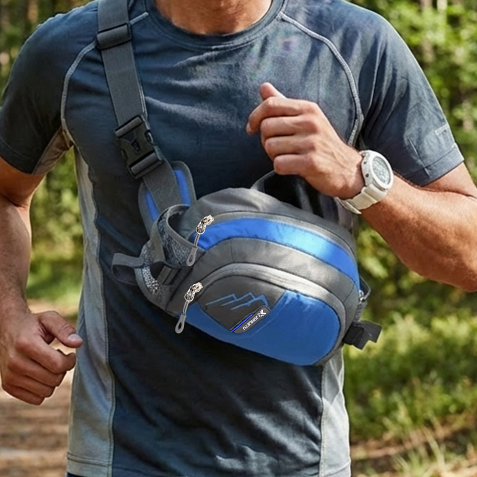 Mann in blauem Shirt mit Umhängetasche beim Laufen im Wald.