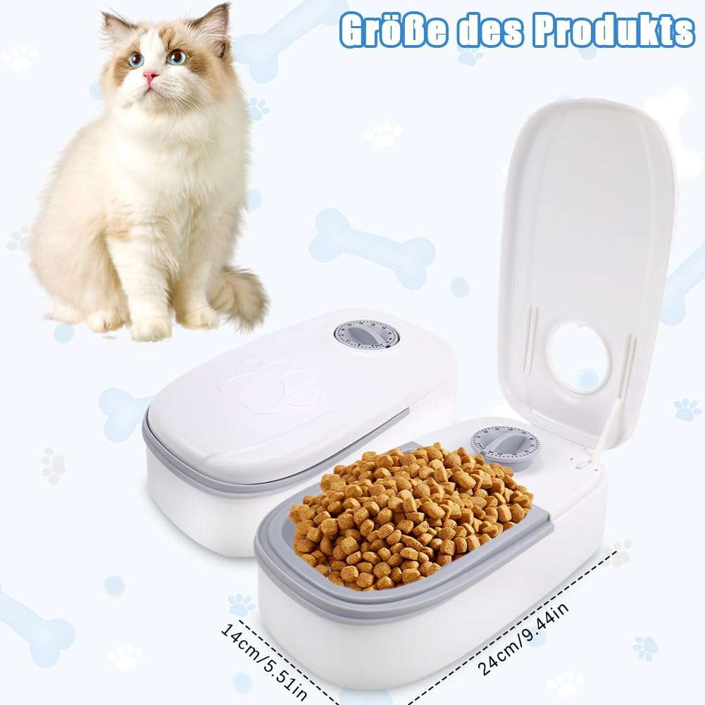 Eine Katze sitzt neben zwei weißen Futterautomaten, einer gefüllt mit Futter.