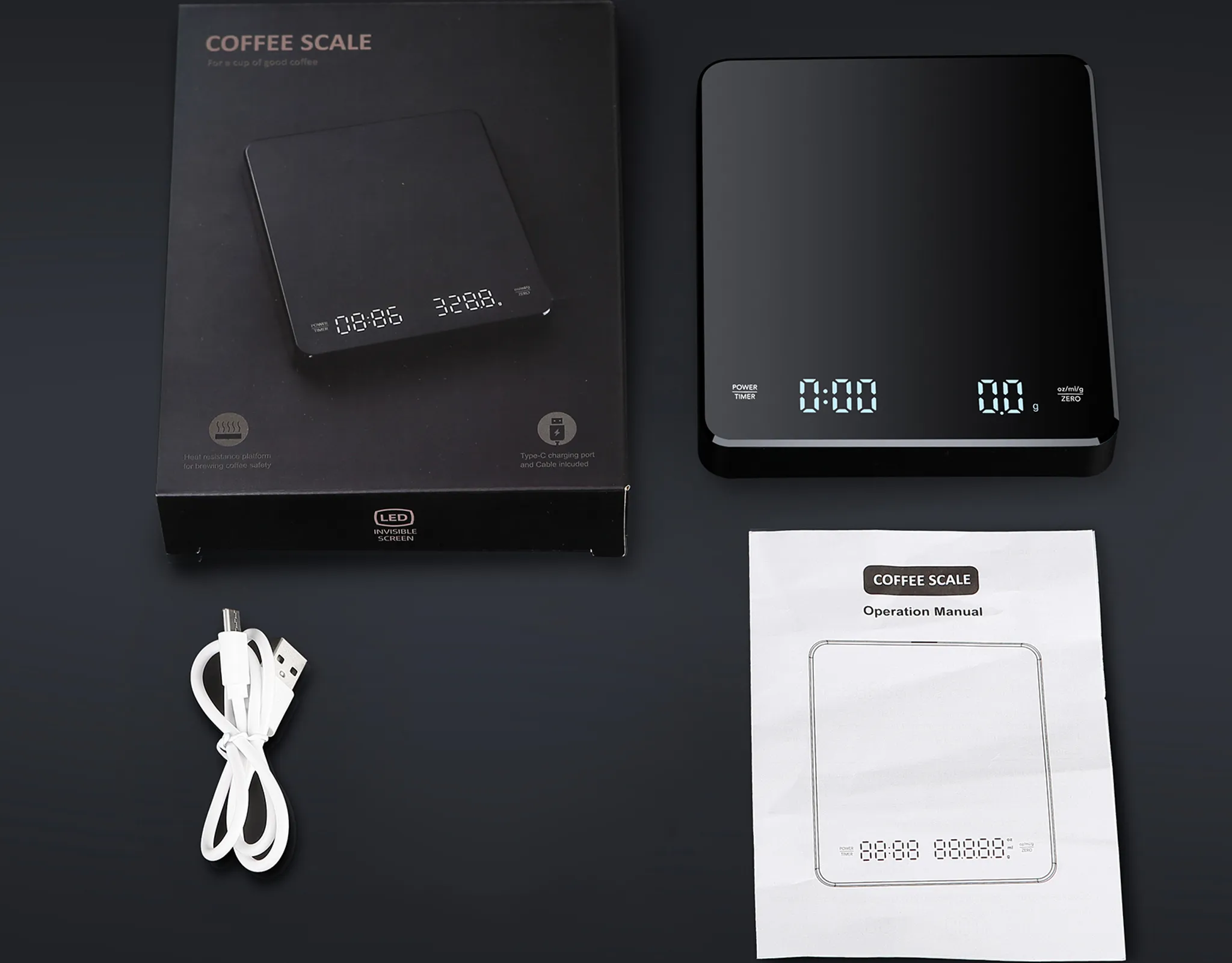 Eine schwarze Kaffeewaage, ein USB-Kabel und eine Anleitung sind auf einer dunklen Oberfläche zu sehen.