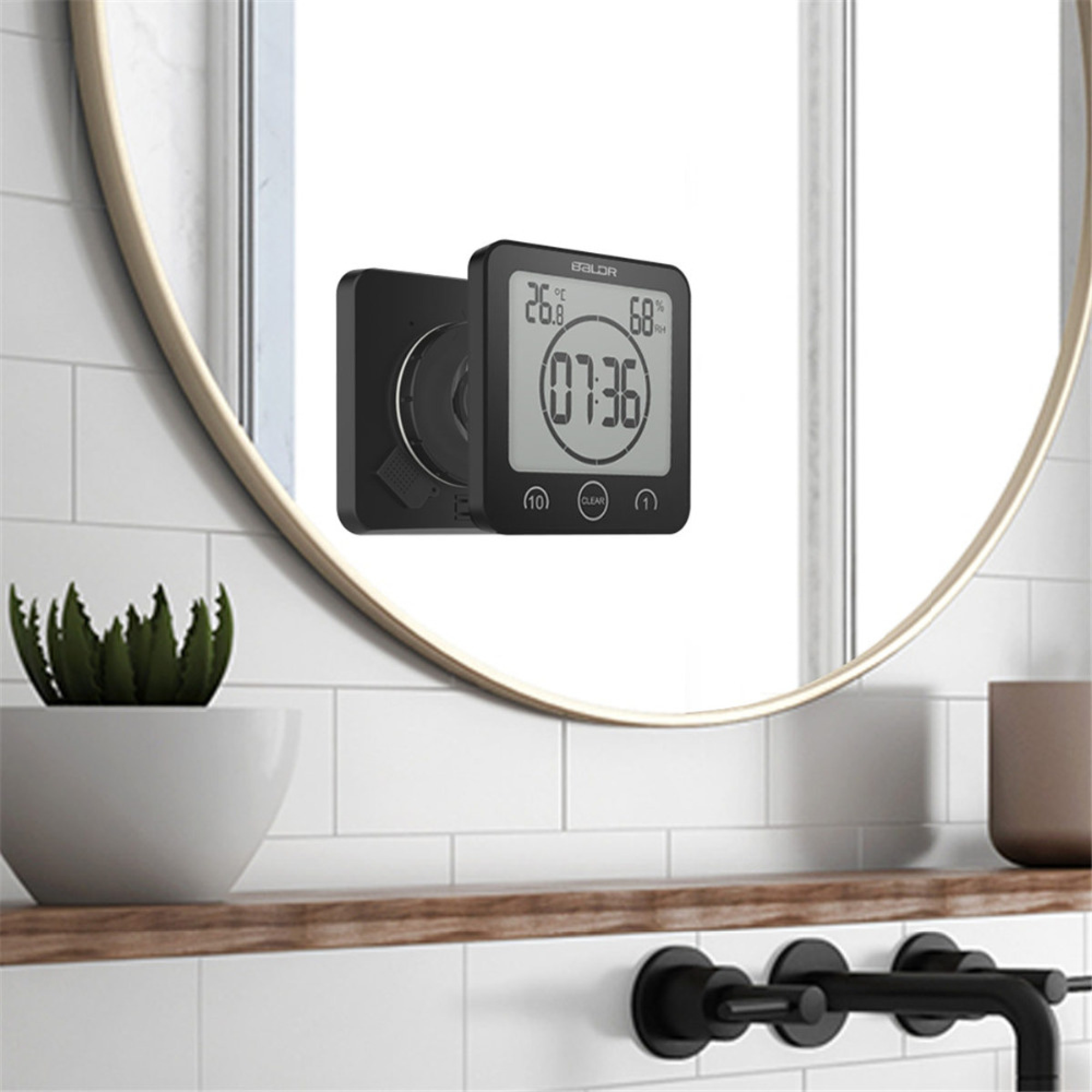 Digitaler Timer mit Temperatur- und Feuchtigkeitsanzeige, spiegelt sich in einem Spiegel.