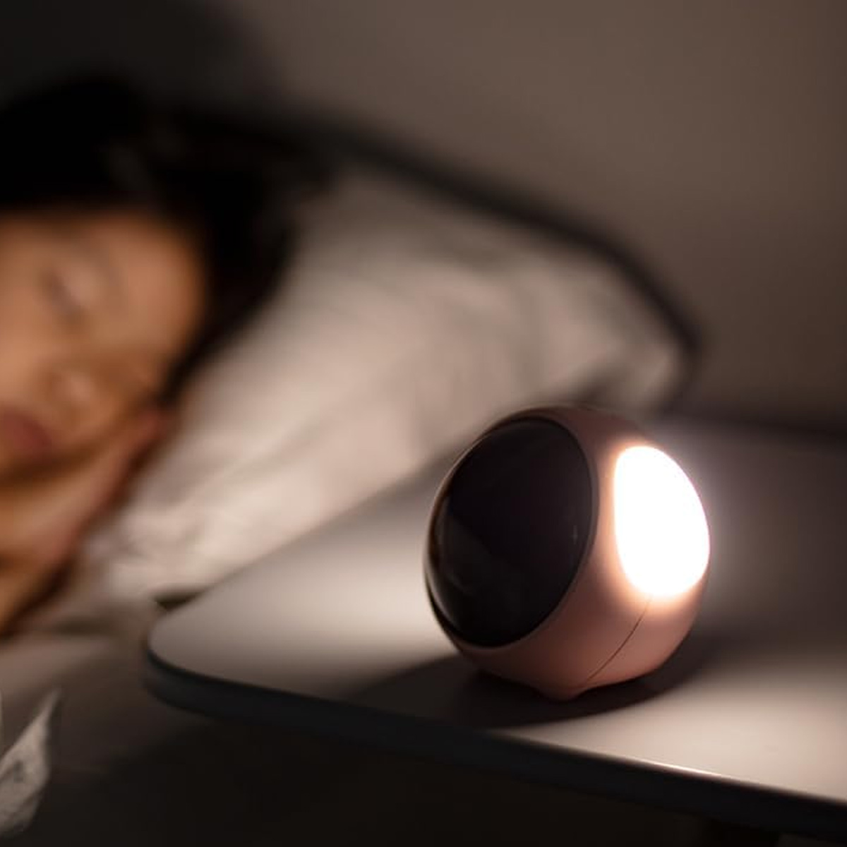 Ein kleines Nachttischlicht leuchtet neben einem schlafenden Kind.