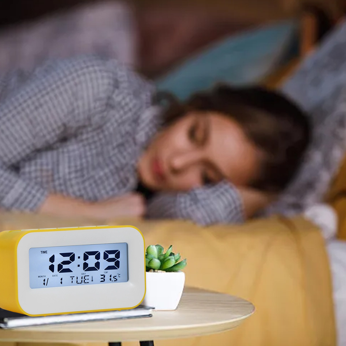 Eine Person schläft, ein gelber Wecker zeigt 12:09 an.