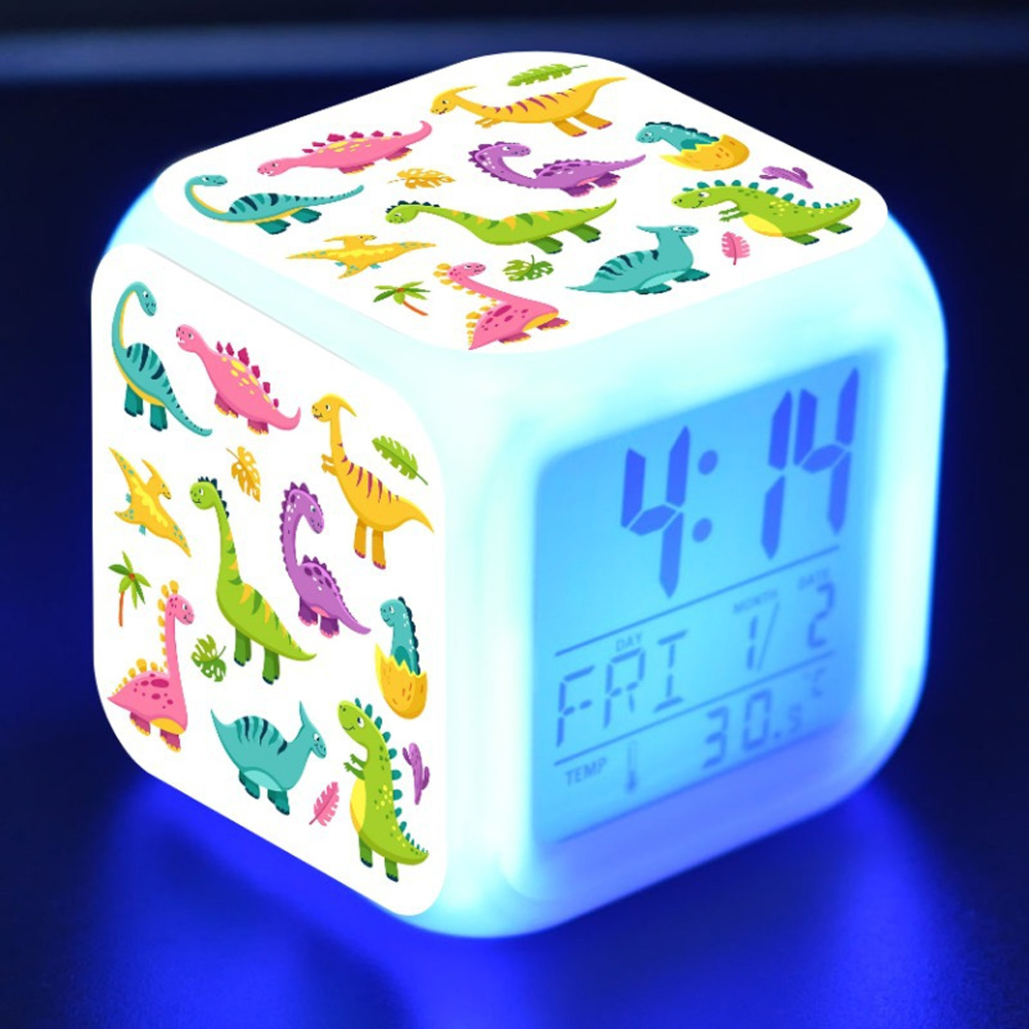 Ein leuchtender Würfel-Wecker mit Dinosaurier-Motiven und digitaler Anzeige.