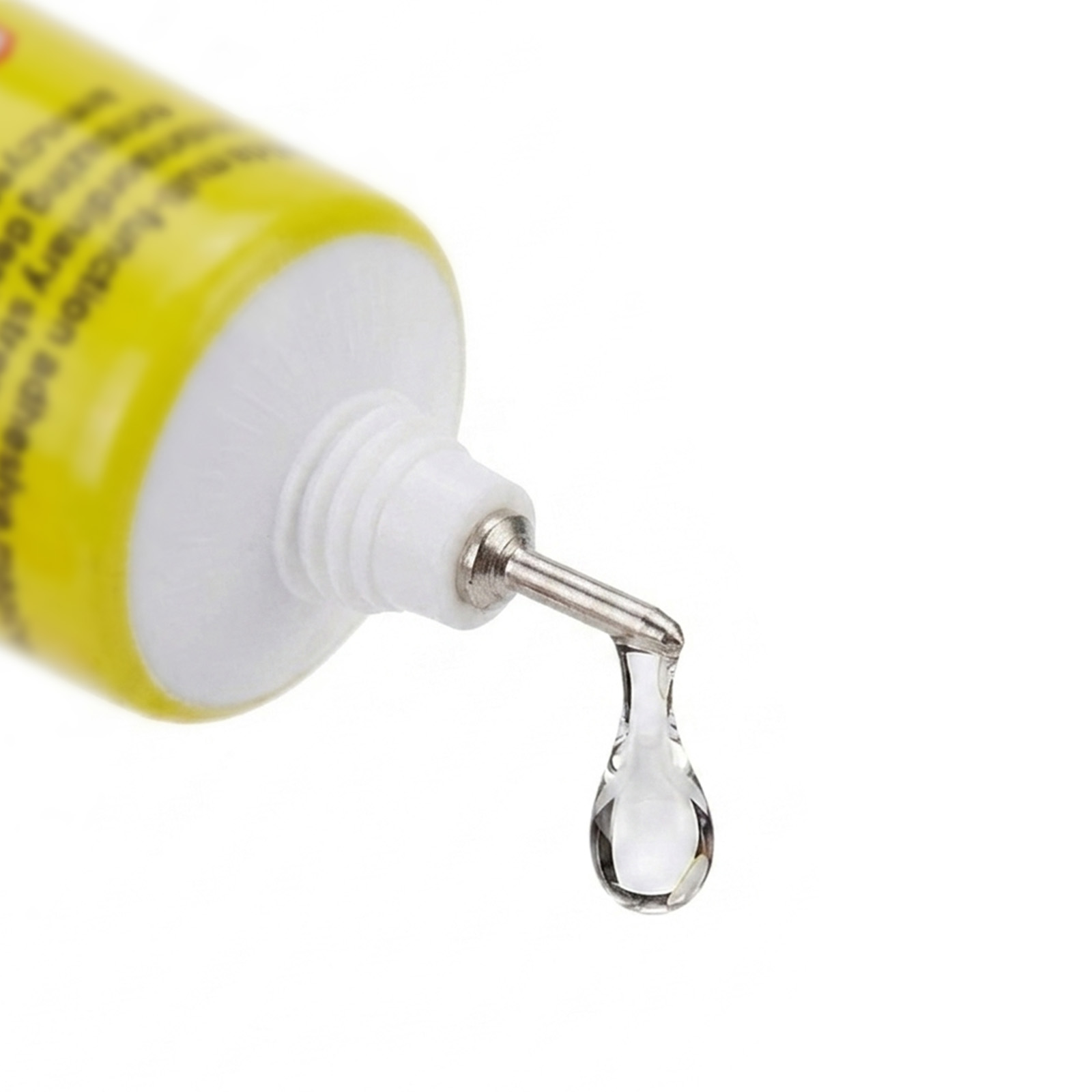 Un tubo giallo con applicatore argentato, una goccia di adesivo trasparente cade.
