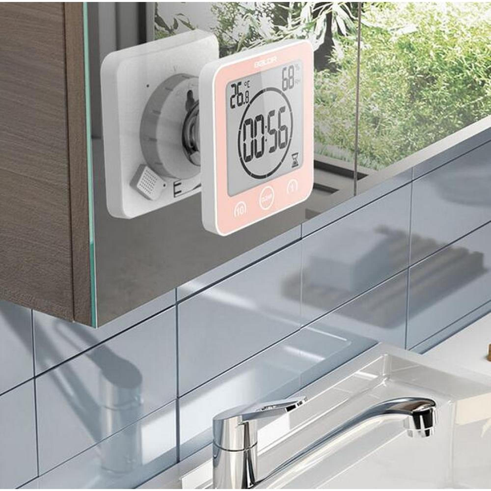 Digitaler Timer mit rosa Rahmen zeigt 26,8°C und 00:56 an. Daneben ein Wasserhahn.