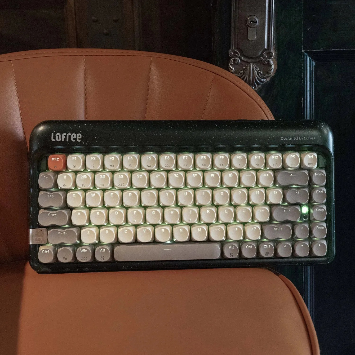 Podświetlana klawiatura Lofree z klawiszami w stylu retro na brązowym krześle.