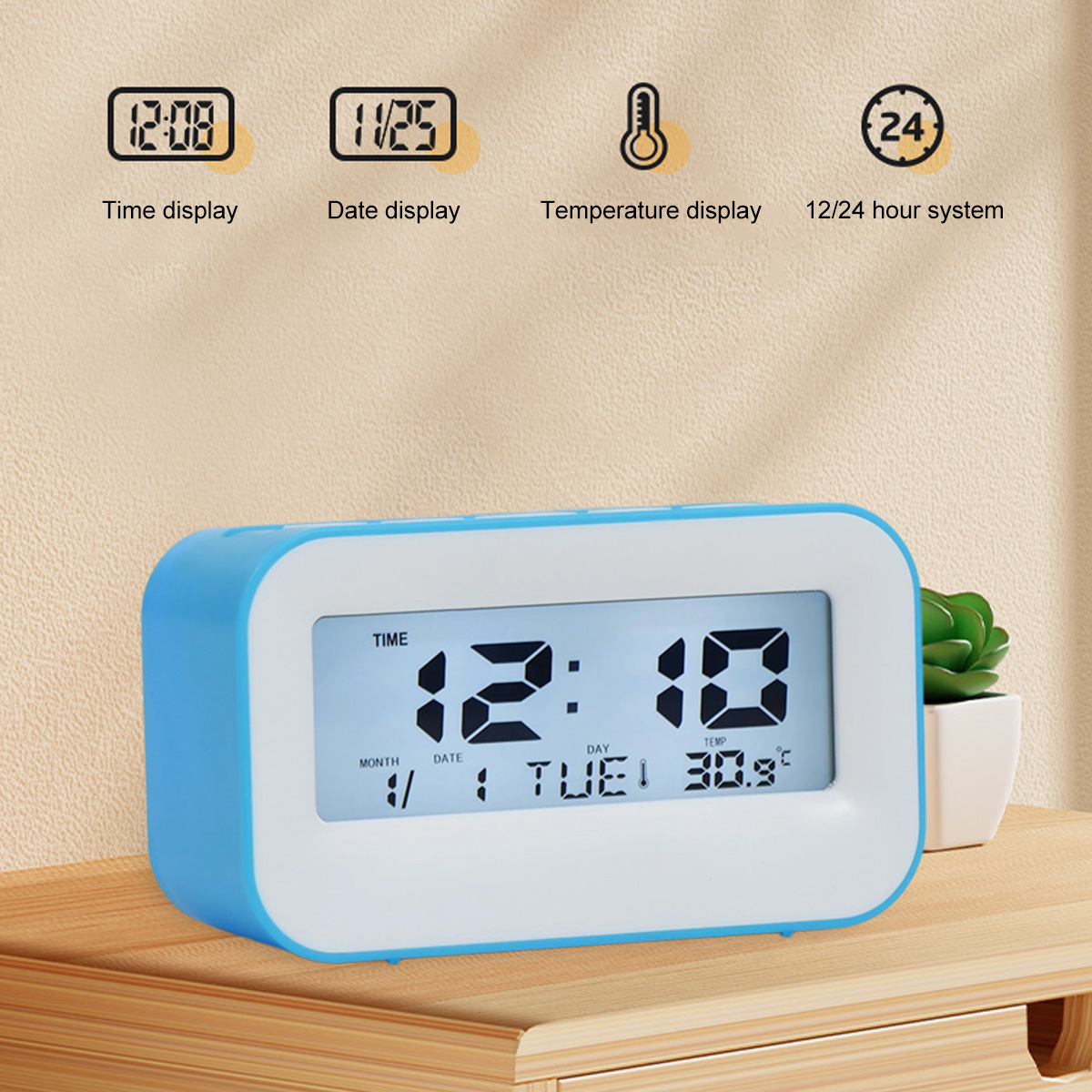 Ein blauer Digitalwecker zeigt 12:10 Uhr, Dienstag, 30.9°C auf einem Holztisch.