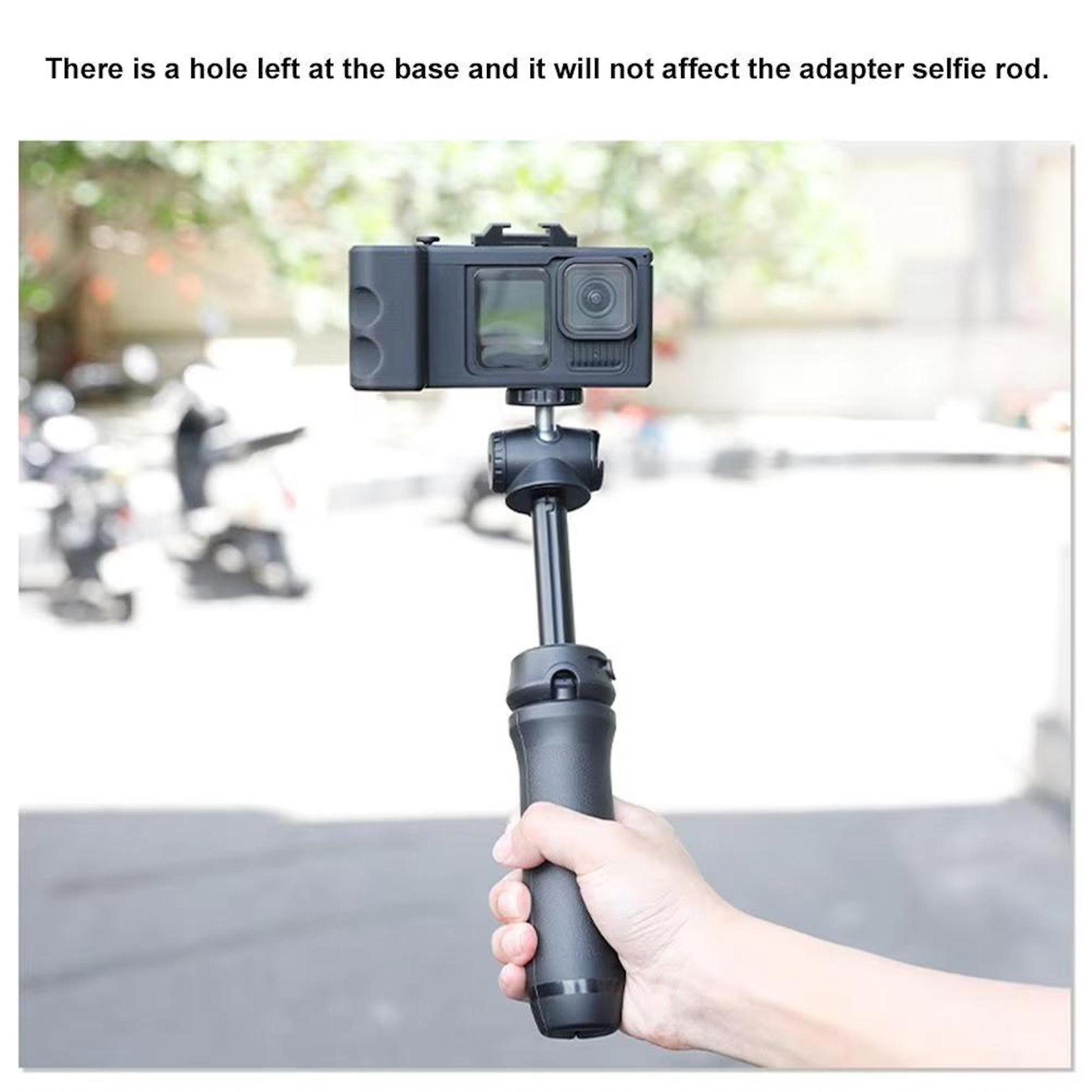 Eine Hand hält einen schwarzen Selfie-Stick mit einer Kamera.