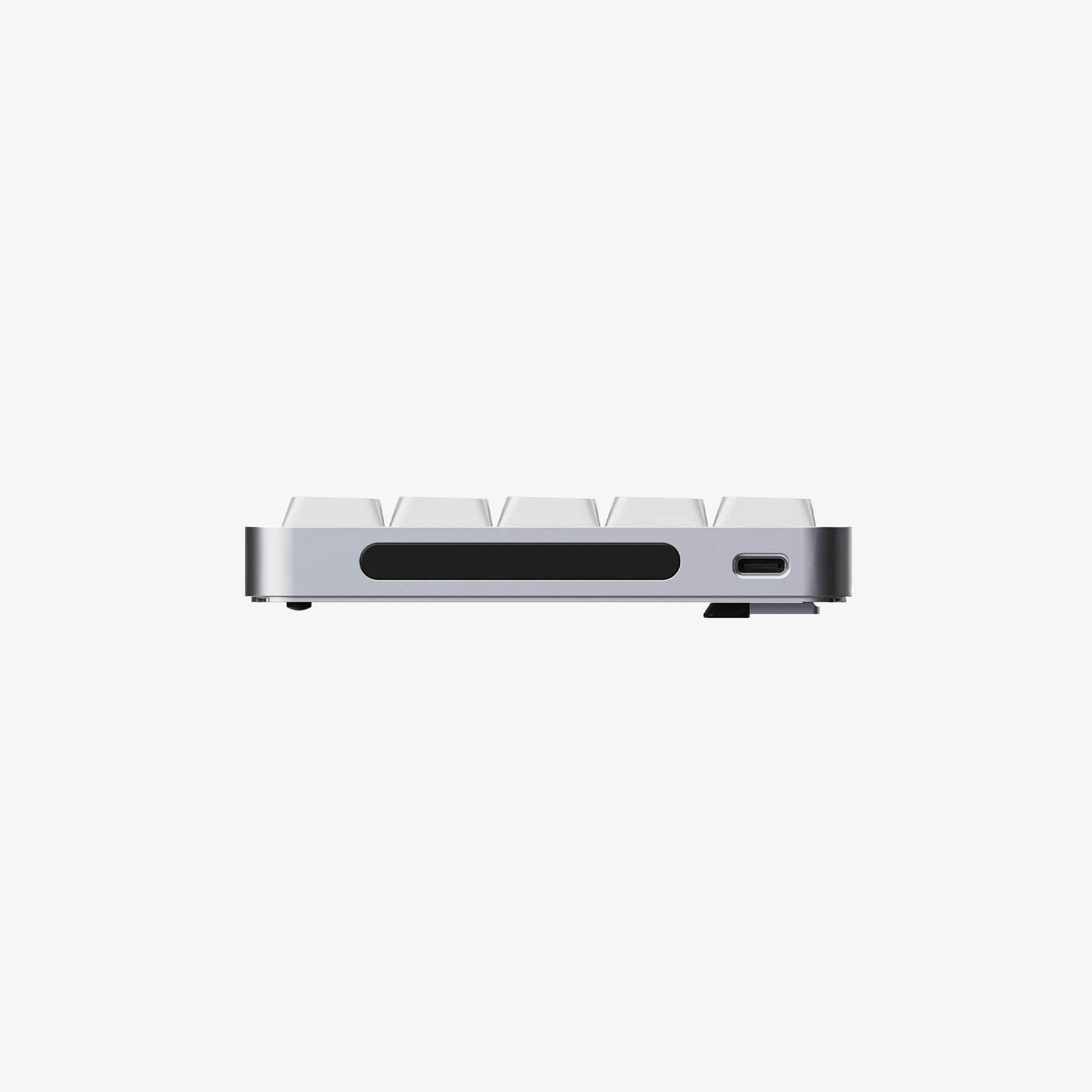 Srebrna klawiatura z boku, z białymi klawiszami i portem USB-C.