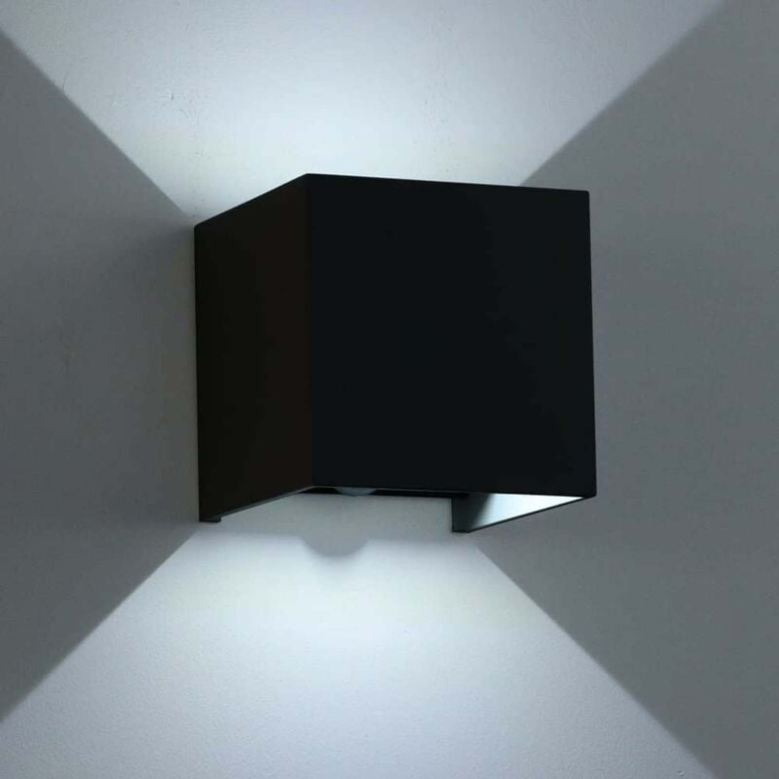 Ein moderner schwarzer Würfel-Wandleuchter wirft Licht nach oben und unten.