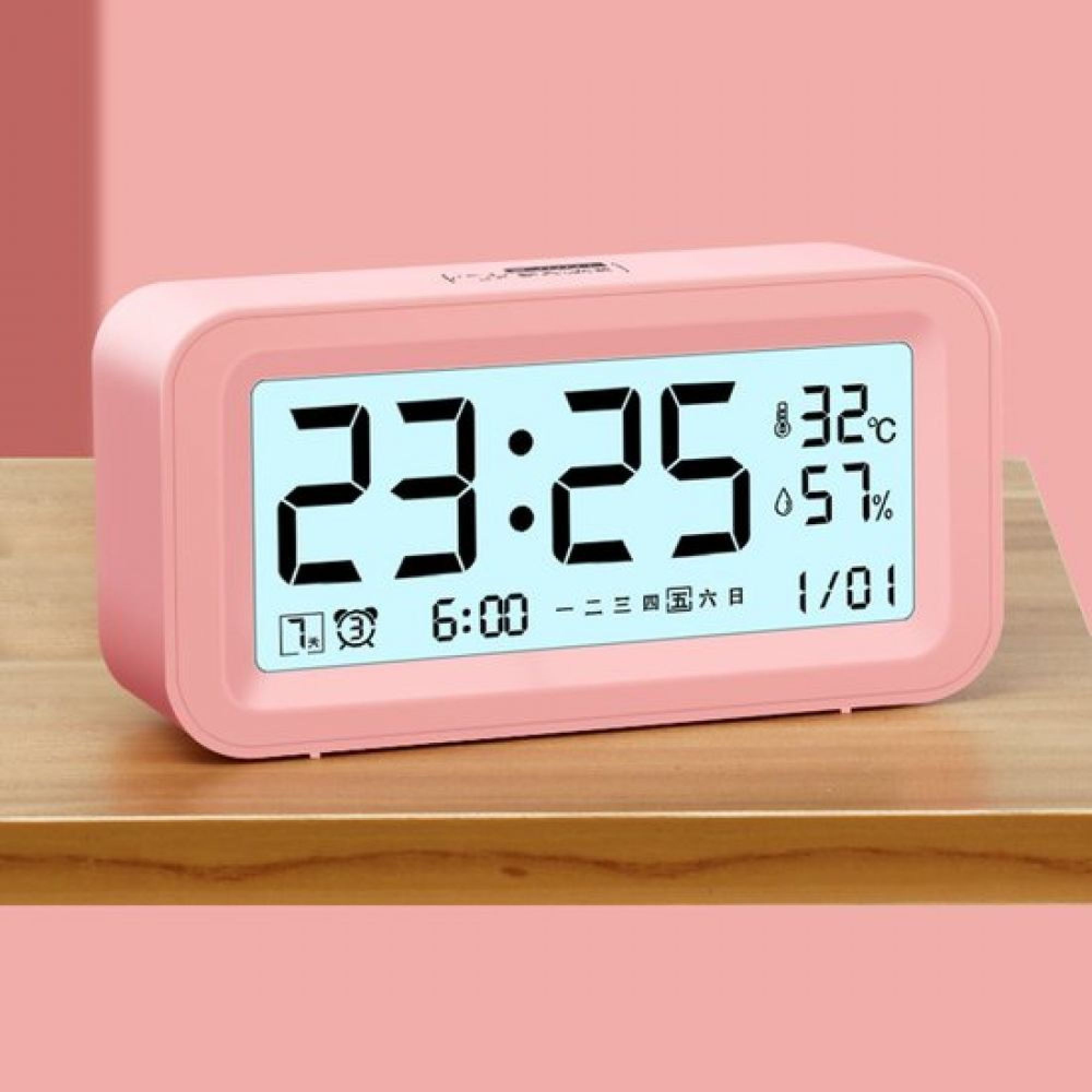 Ein rosafarbener Digitalwecker zeigt 23:25, 32°C, 57% Luftfeuchtigkeit und 1/01 an.