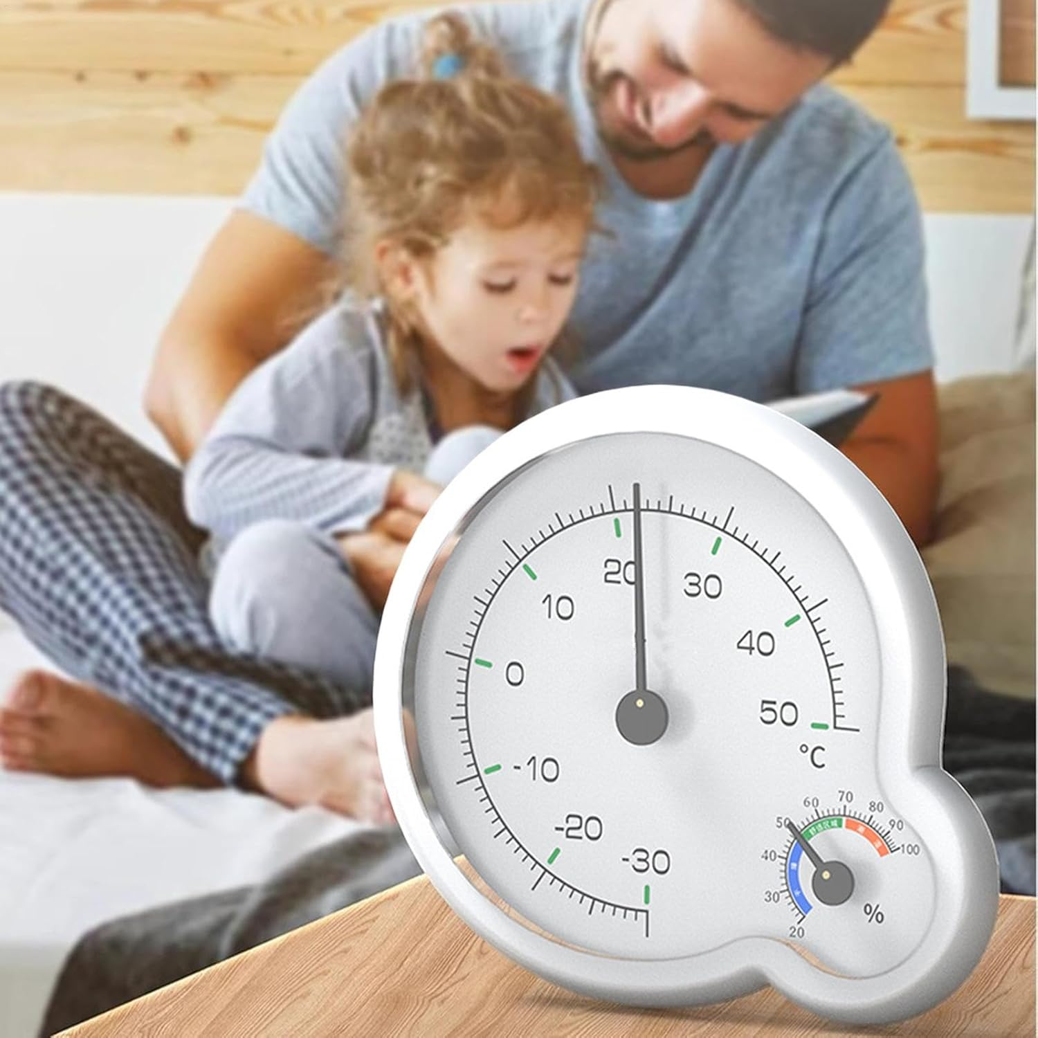 Ein Thermometer und Hygrometer auf einem Tisch vor einem Vater und Kind.