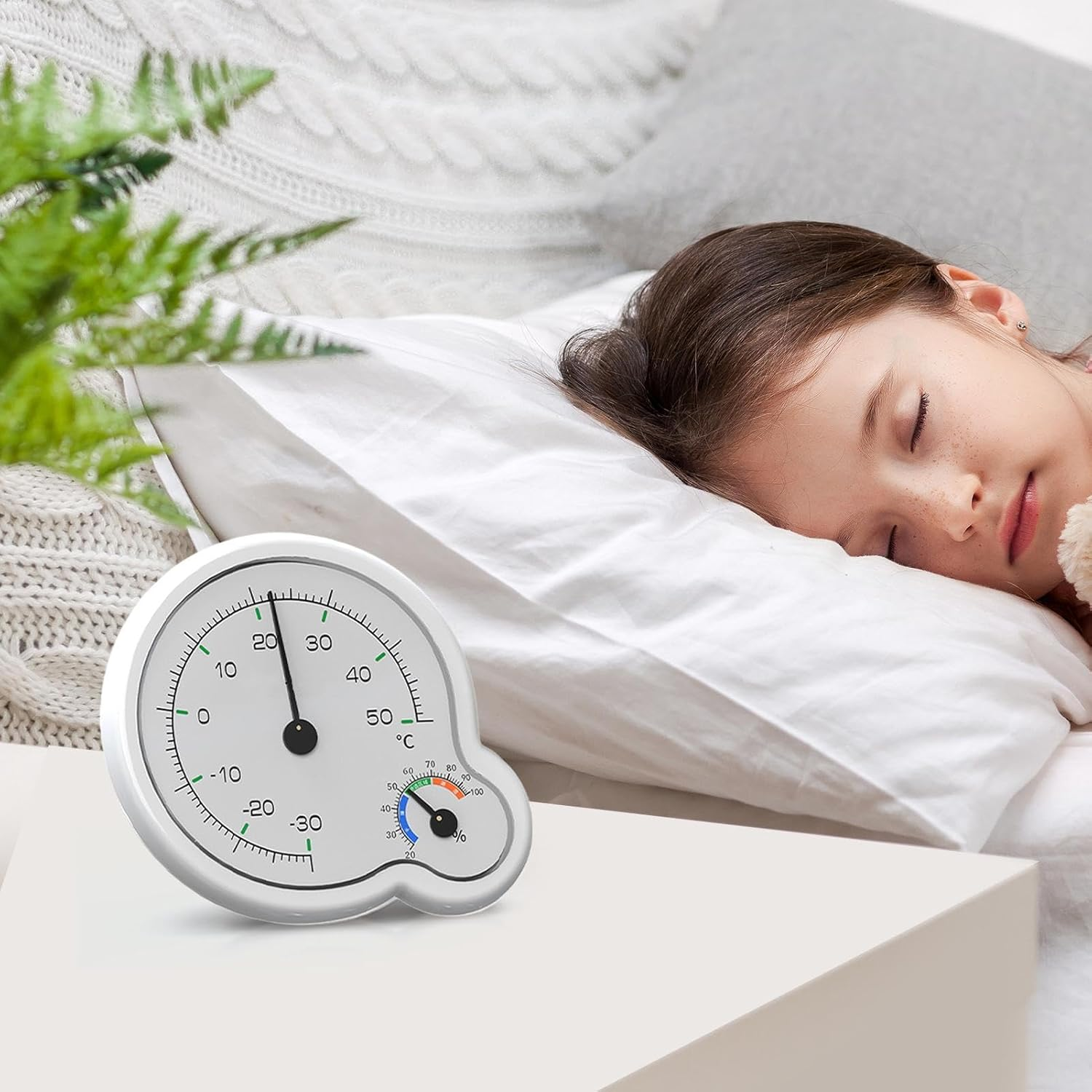 Ein Thermometer und Hygrometer neben einem schlafenden Mädchen.