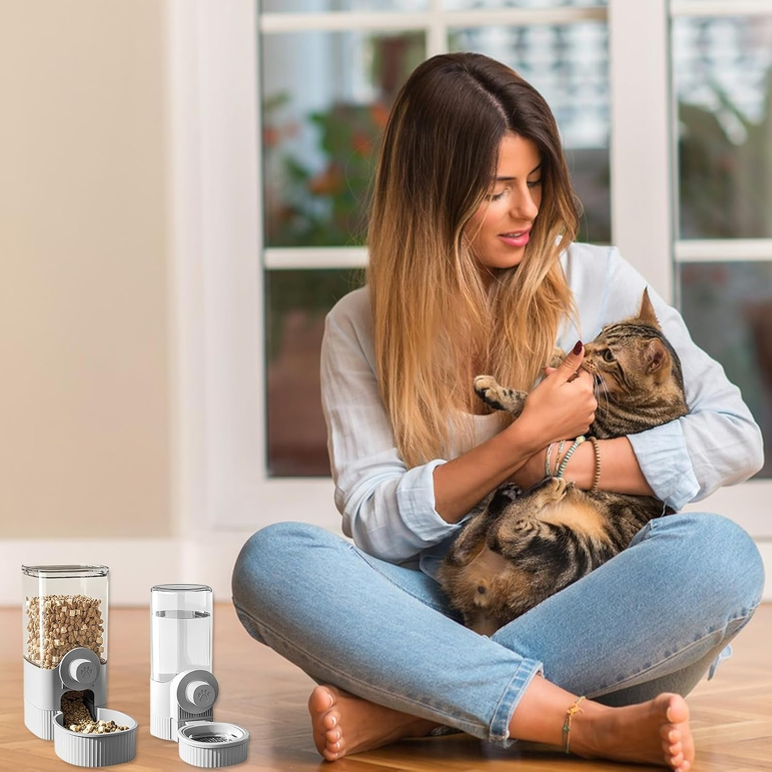 Frau in Jeans hält Katze. Tierfutterspender auf dem Boden.