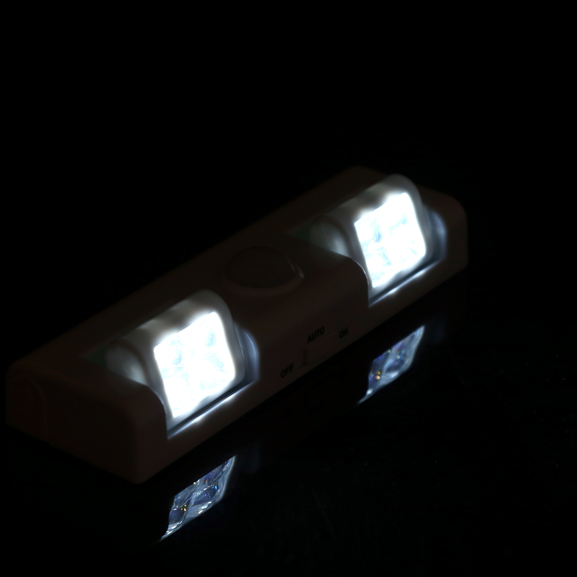 Ein weißes LED-Nachtlicht mit zwei Lichtern und einem Schalter.