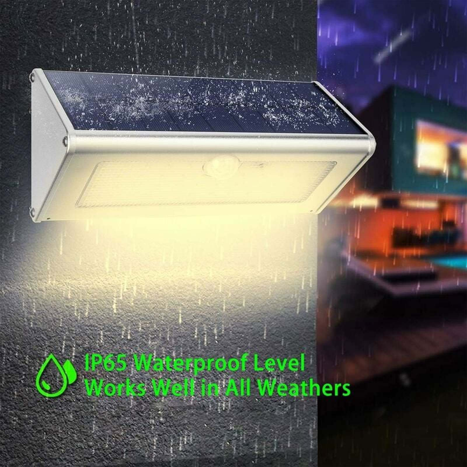Solarleuchte mit Bewegungsmelder an einer Wand, im Regen beleuchtet.