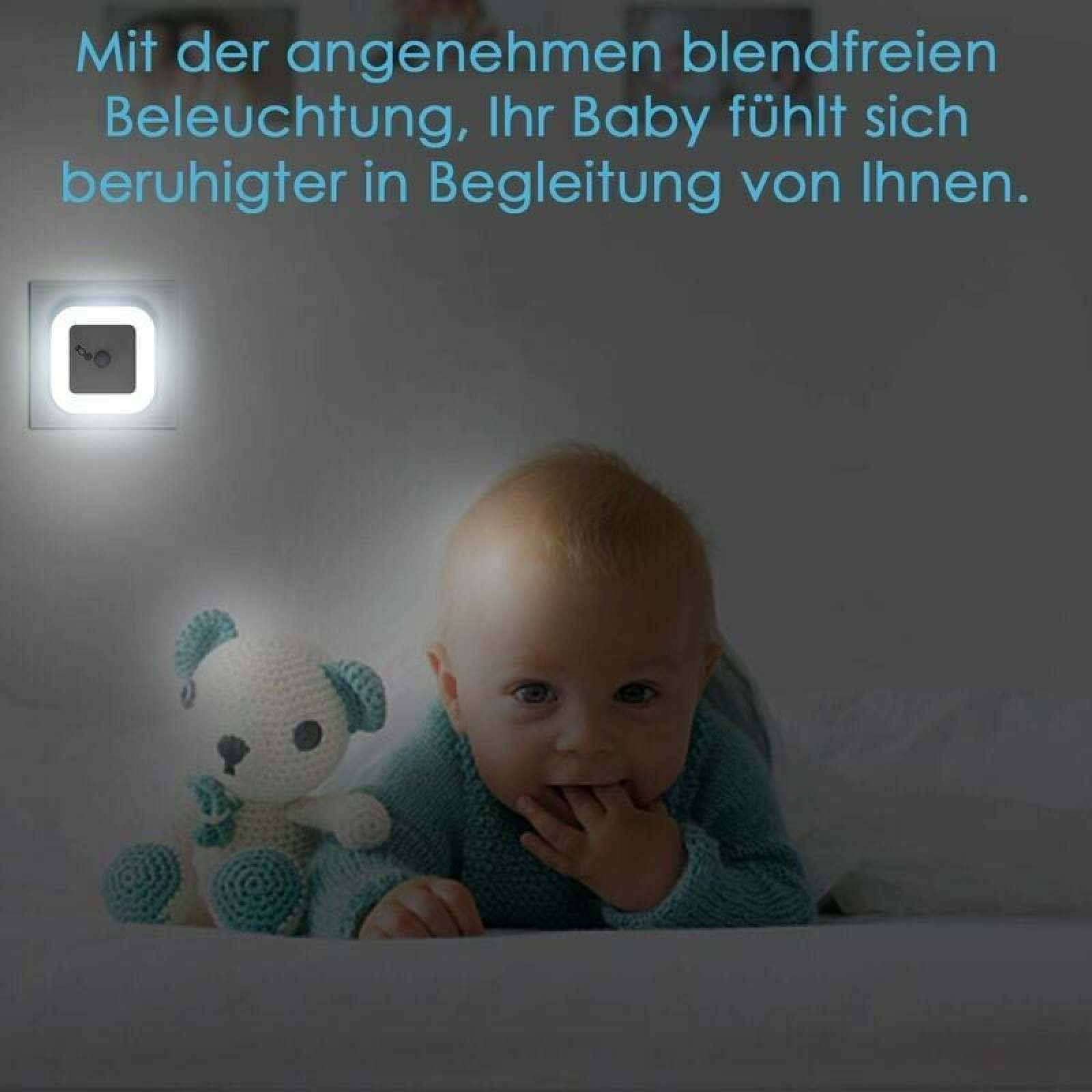 Ein Baby liegt neben einem Teddybär, beleuchtet von einem Nachtlicht.